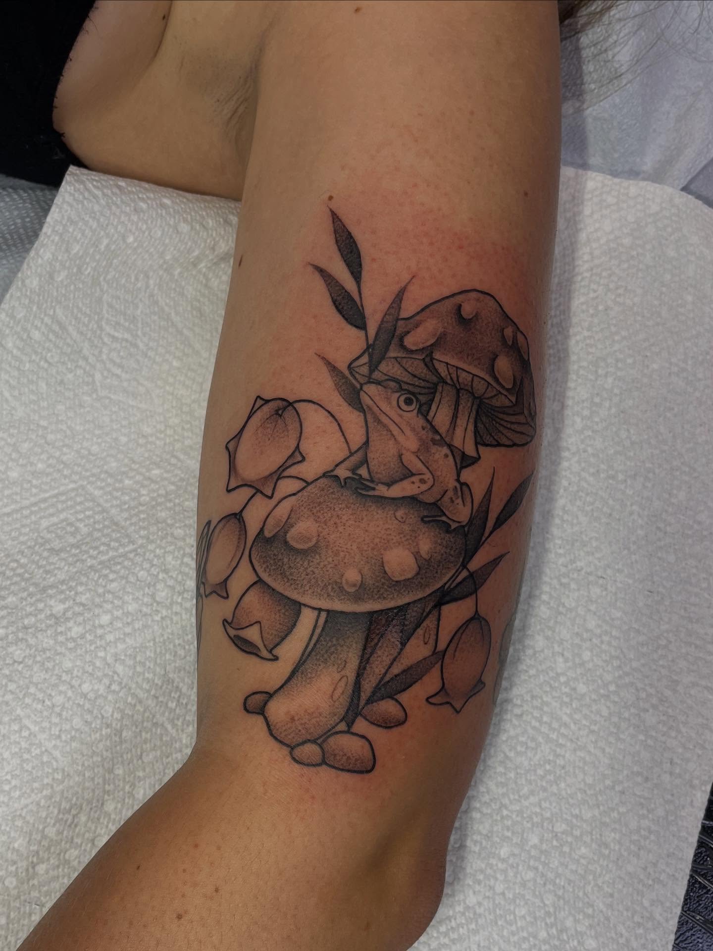 Mushroom and frog dotwork tattoo on the forearm by Lauren Bumgardner