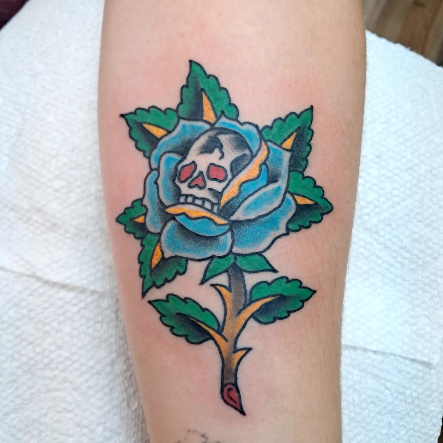 Skull and rose American traditional tattoo on the forearm by Reb Fularz