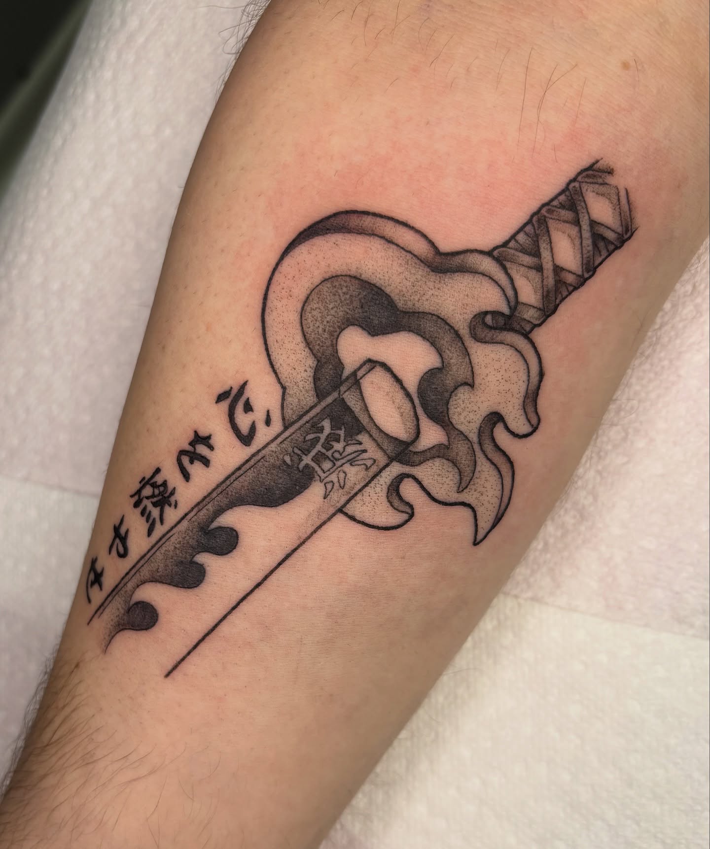 Sword with flame black and grey tattoo on the forearm by Lilac Rose