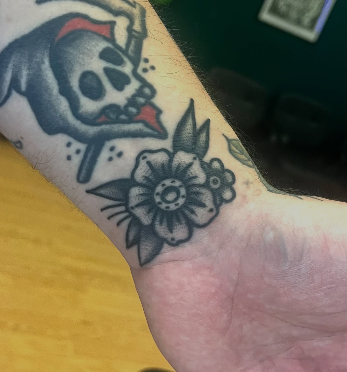 Skull and flower American traditional tattoo on the forearm by August B., Renton, Washington