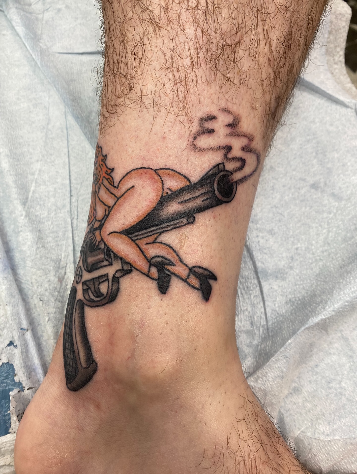 Gun and woman American traditional tattoo on the forearm by Mike Tapia