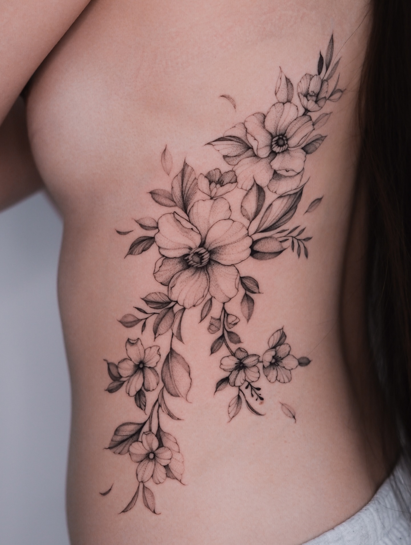 Flower bouquet black and grey tattoo on the ribs by Tattoo artist in Boston