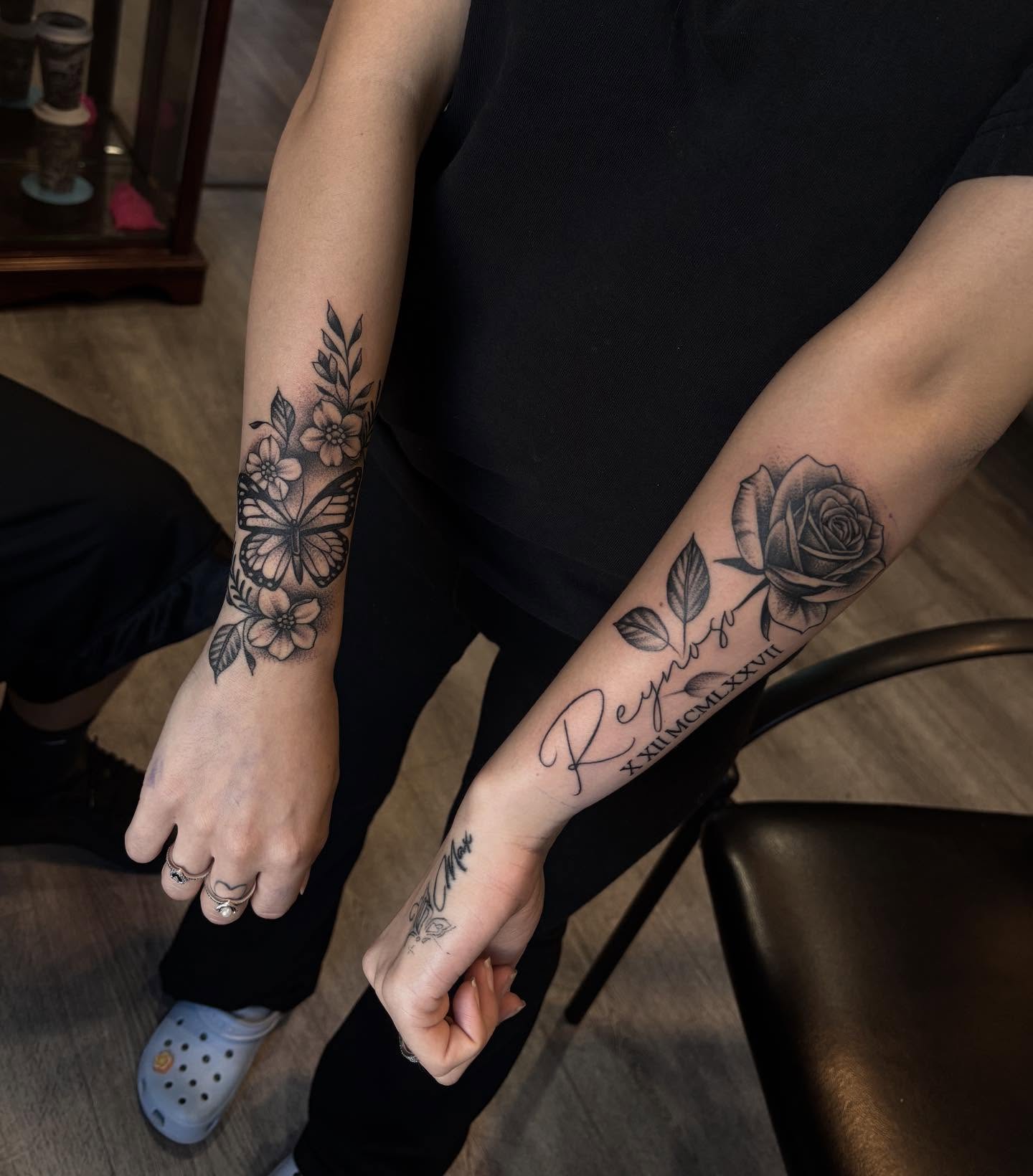 Floral and butterfly black and grey tattoo on the forearm by michael