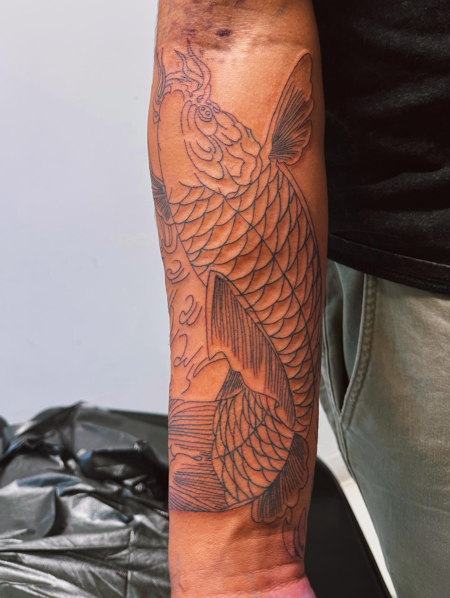 Koi fish black and grey tattoo on the forearm by Idalia Pulido