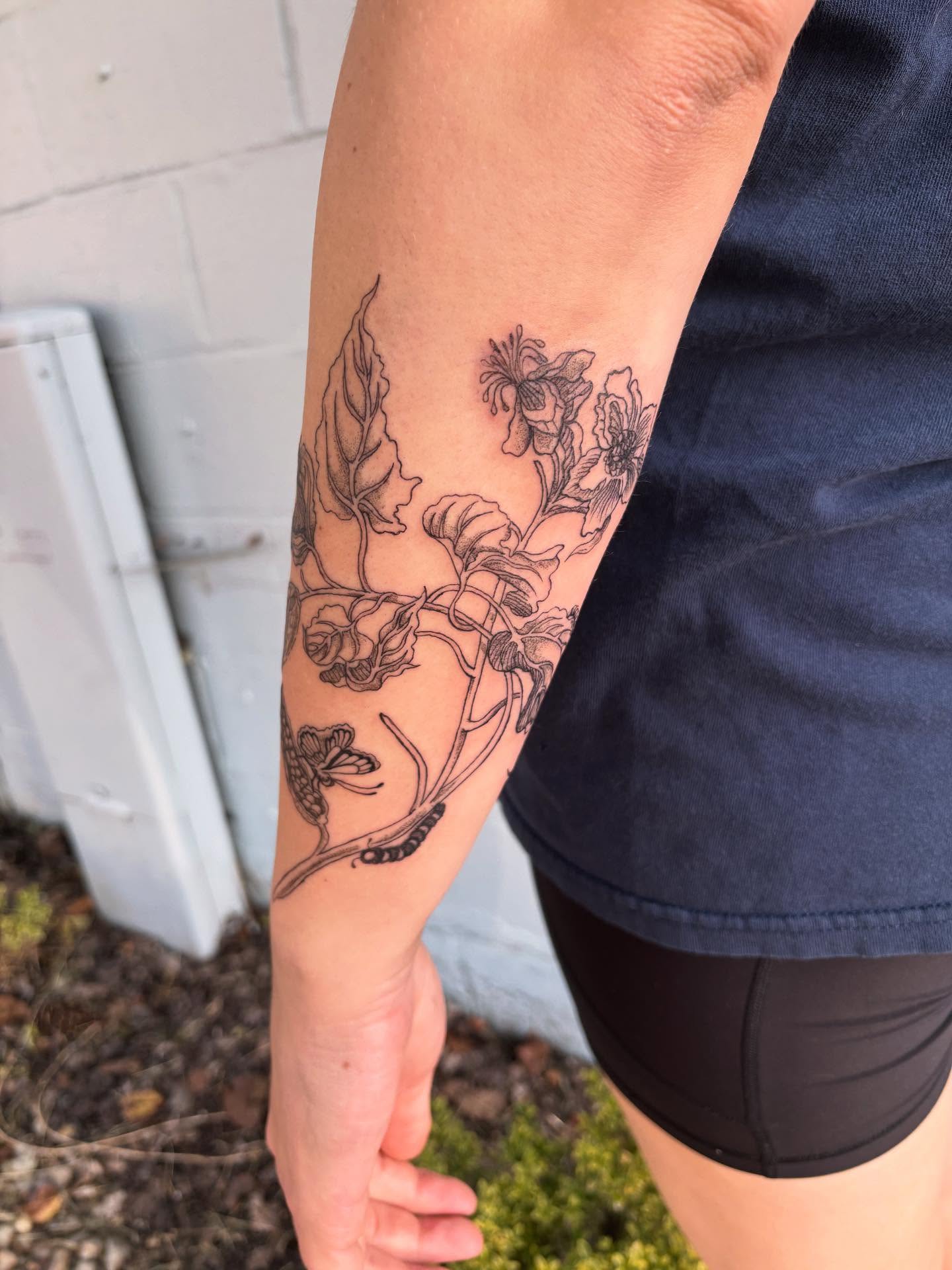 Floral design black and grey tattoo on the forearm by Ashley Ellerman