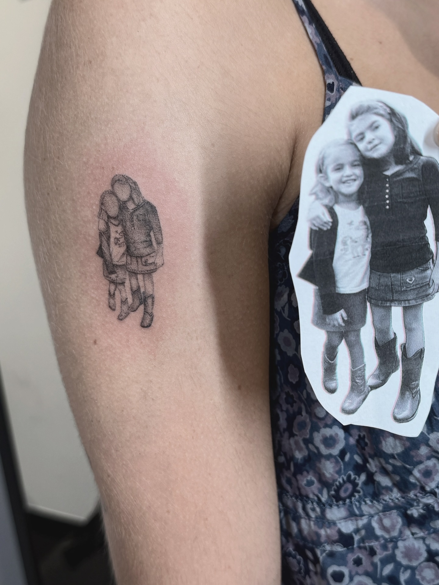 Children walking black and grey tattoo on the upper arm by Raleigh tattoo artist, Raleigh, North Carolina