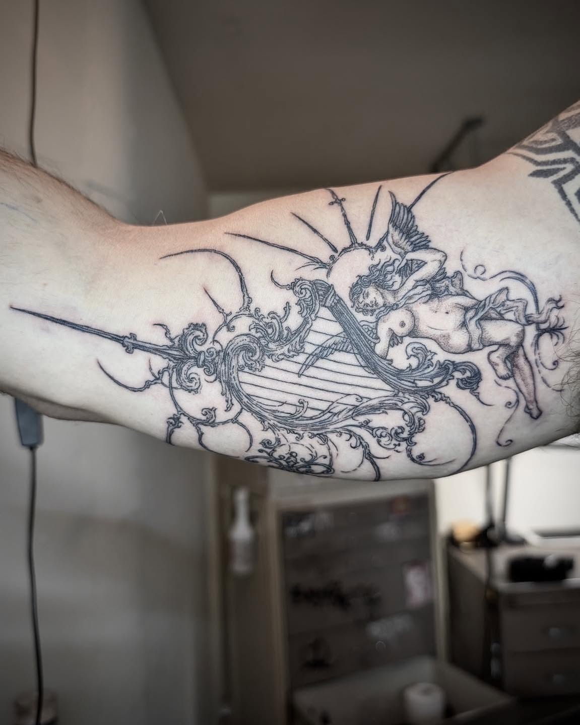 Mythical creature and harp ornamental tattoo on the forearm by Quin Walker