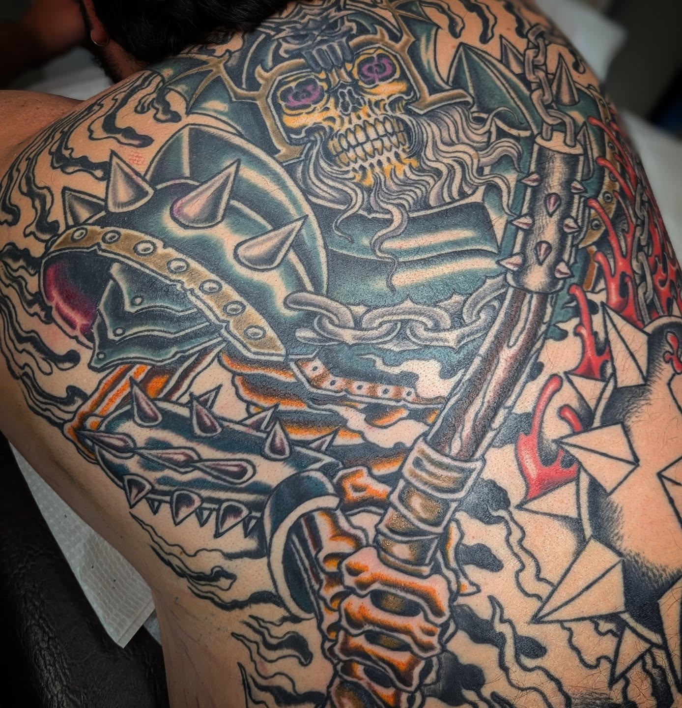Skull and armor American traditional tattoo on the back by Ryan Slegel