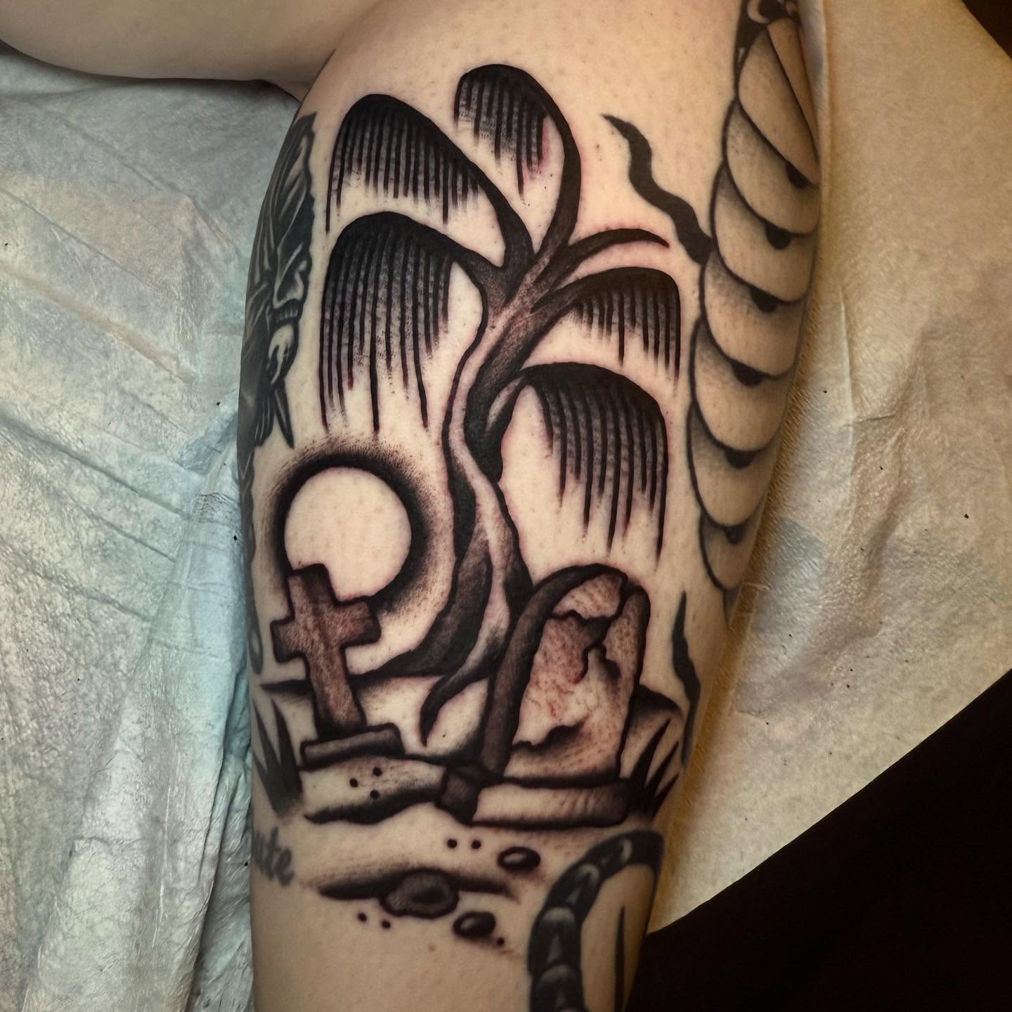 Graveyard scene realism tattoo on the forearm by Julia Louise