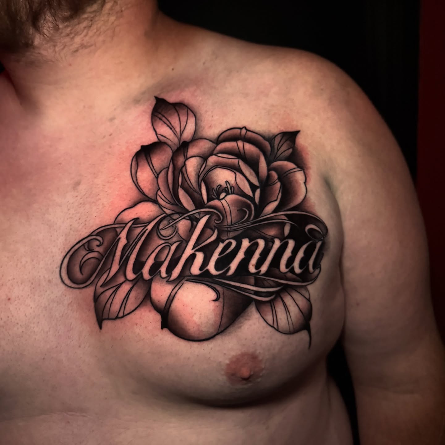 Rose and name black and grey tattoo on the chest by Ryland - Tattoo Artist