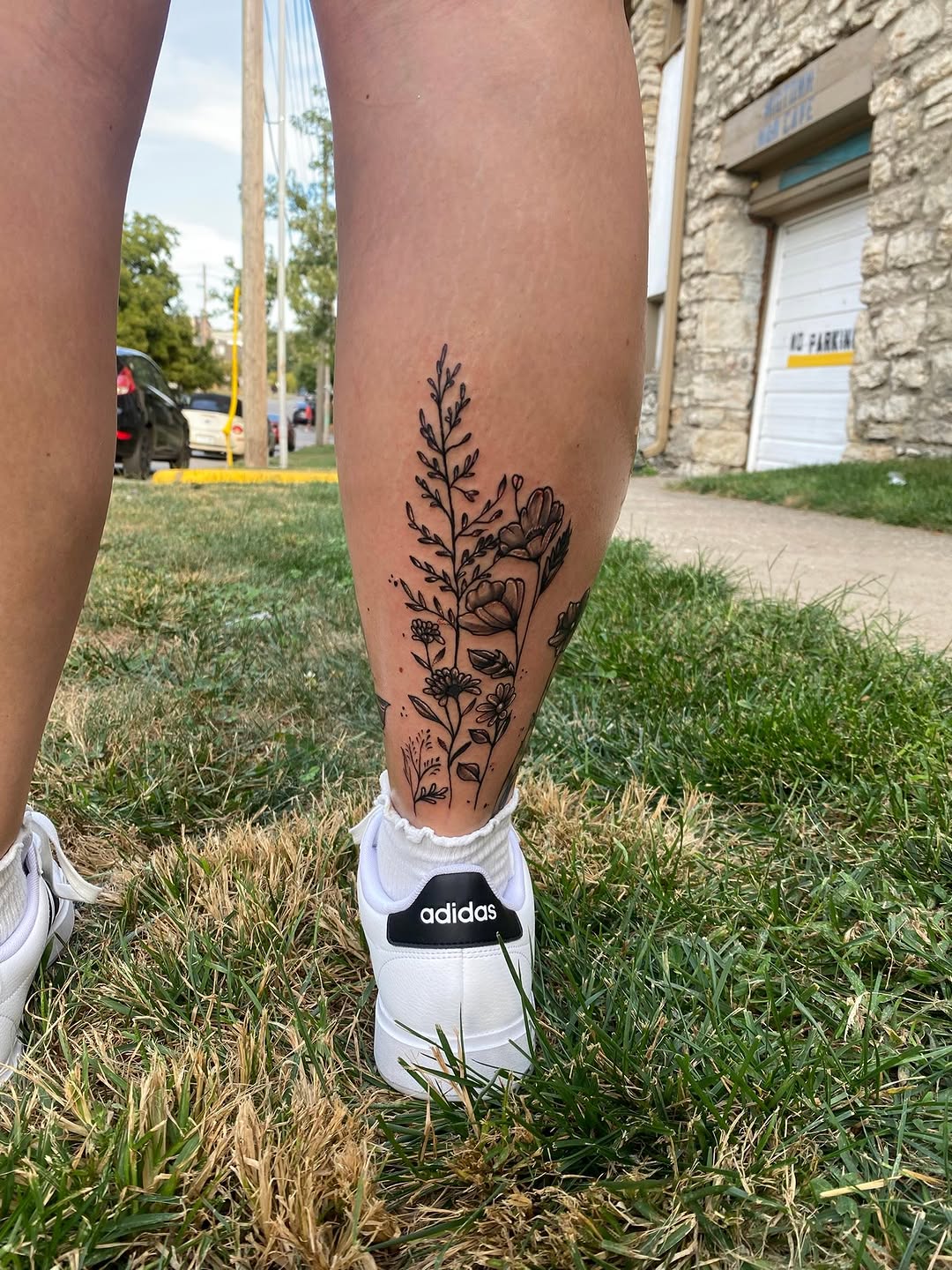 Floral arrangement minimalist tattoo on the calf by Israel Jacob Woehler