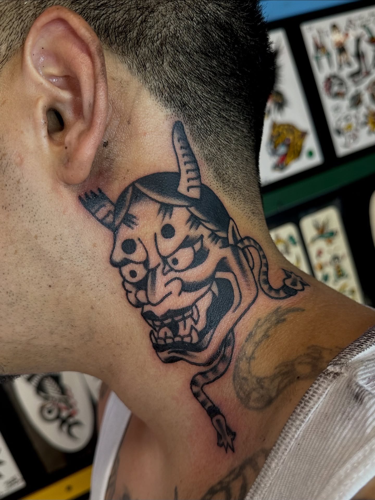 Demon face black and grey tattoo on the neck by Steven