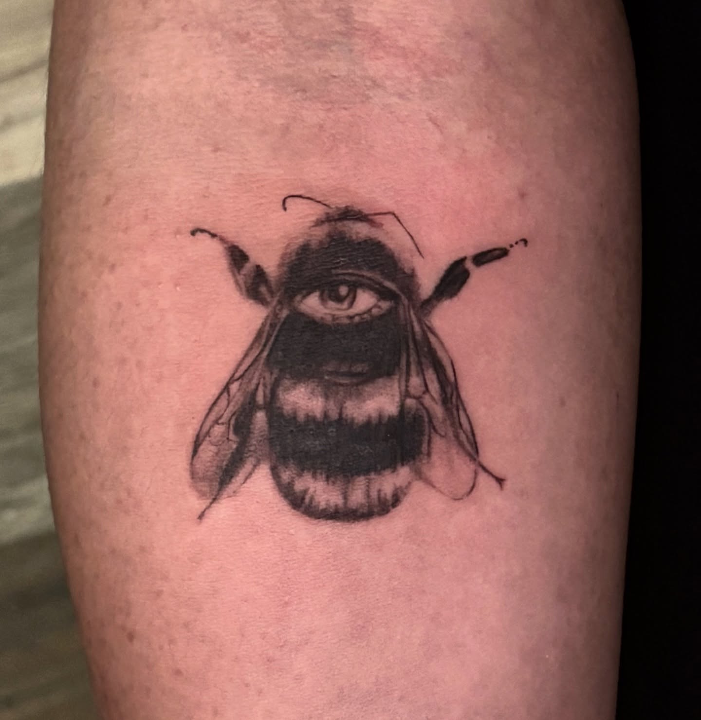 Bee black and grey tattoo on the forearm by jordy