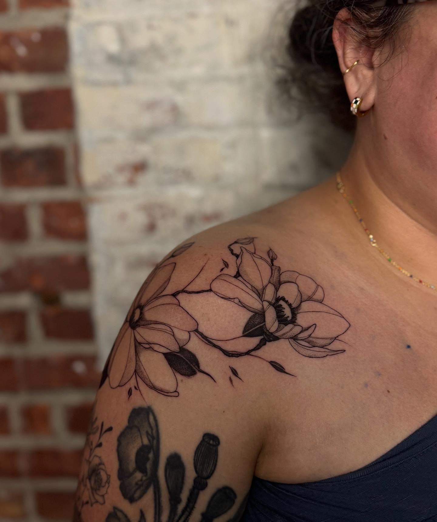 Magnolia flowers black and grey tattoo on the shoulder by Isabel Smith🦋🕷️