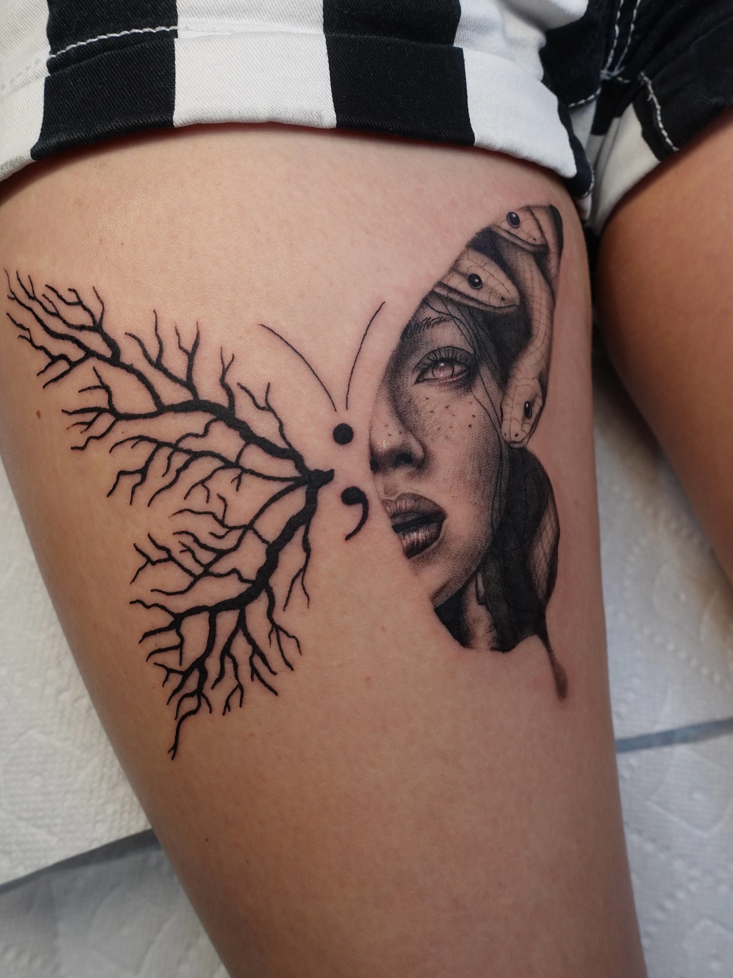 Woman's face with tree roots realism tattoo on the thigh by Tat by Brendan