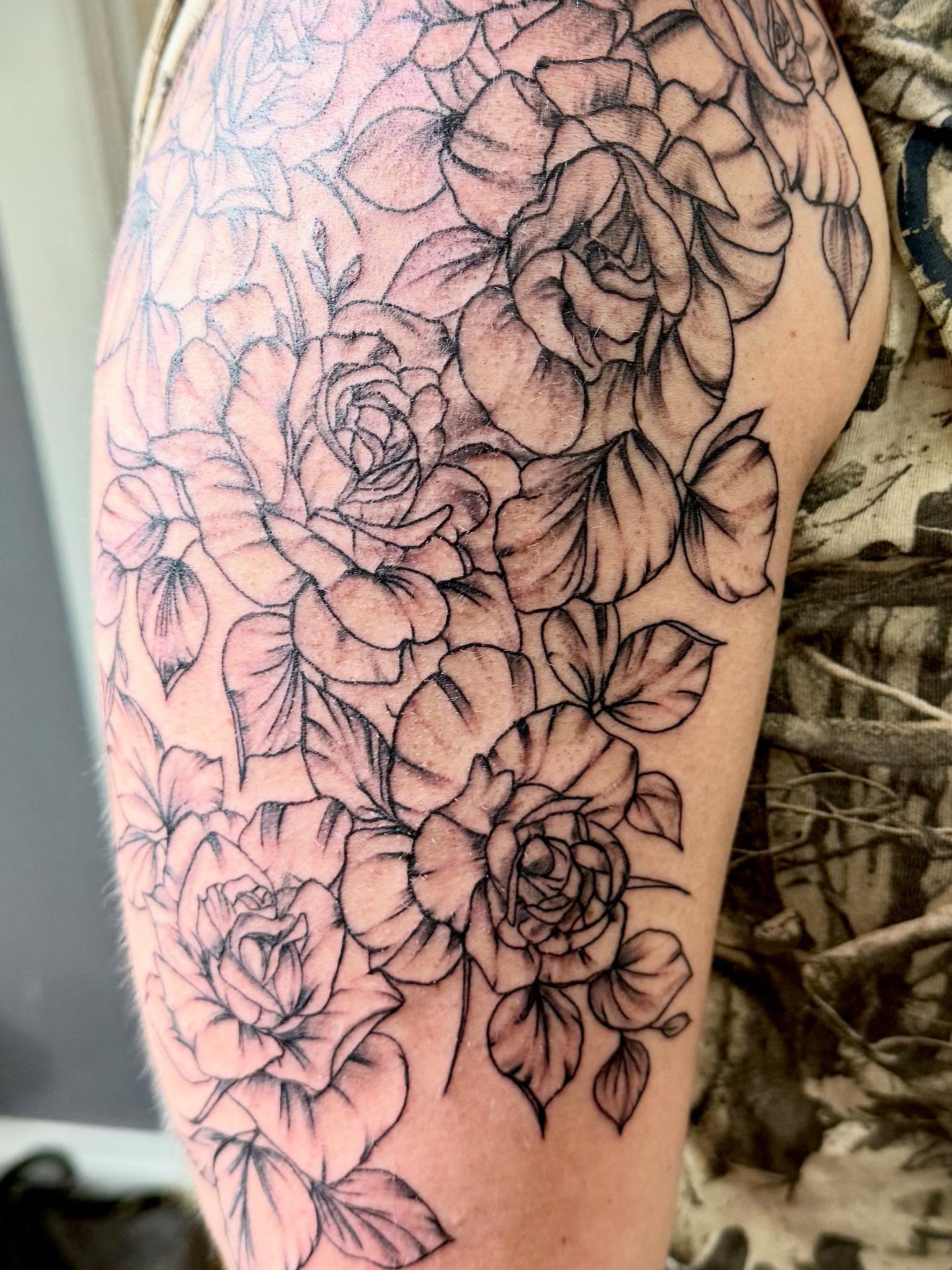 Roses black and grey tattoo on the upper arm by Jillian Pardy