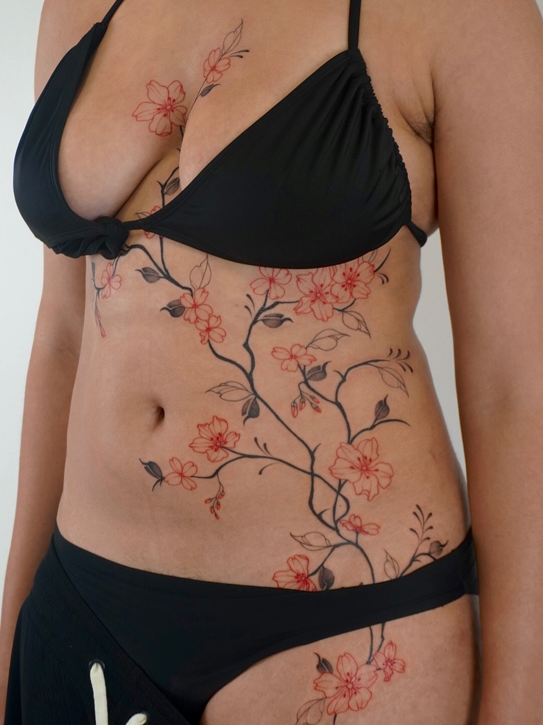 Cherry blossom branch dotwork tattoo on the torso by Sun Child Tattoo 🌻