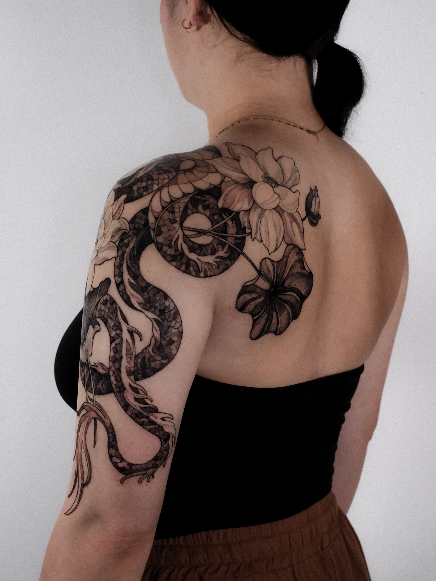 Dragon and lotus realism tattoo on the shoulder by Alena Zozulenko