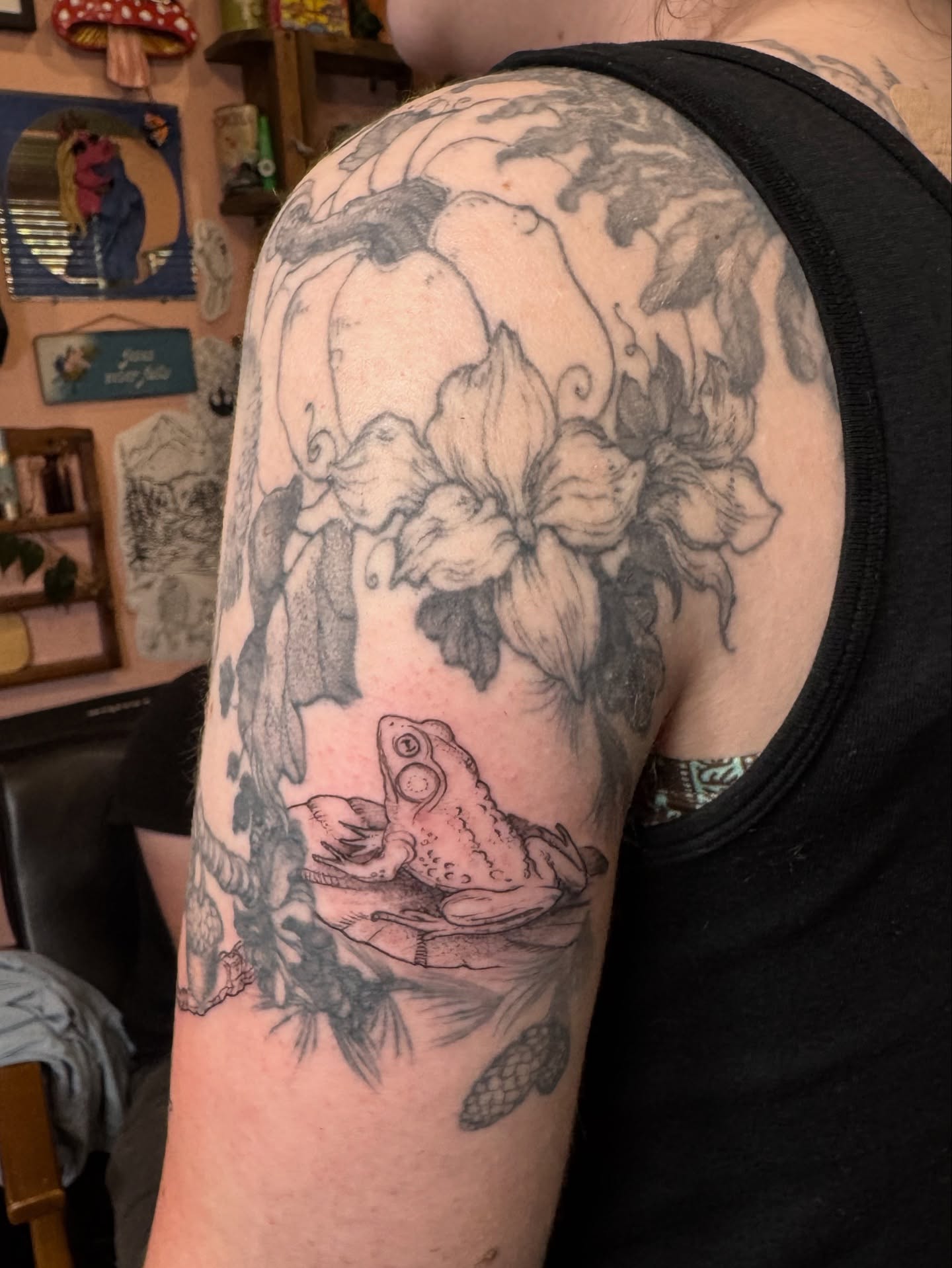 Frog and flowers realism tattoo on the upper arm by Rebeka Chase [Sobodacha]
