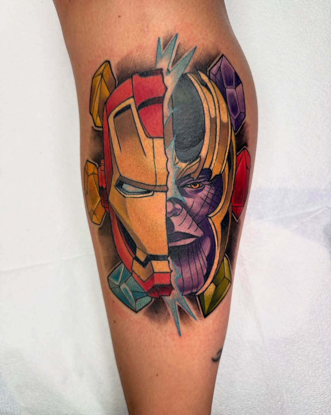 Iron Man and Thanos split portrait surrealism tattoo on the thigh by Kiel Ferrari