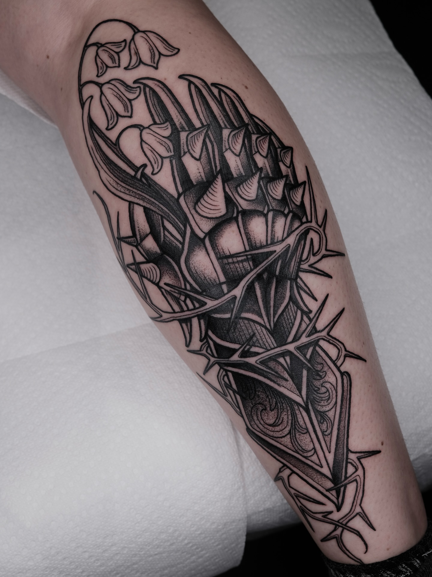 Daffodils and thistle geometric tattoo on the forearm by Kyle Patrick