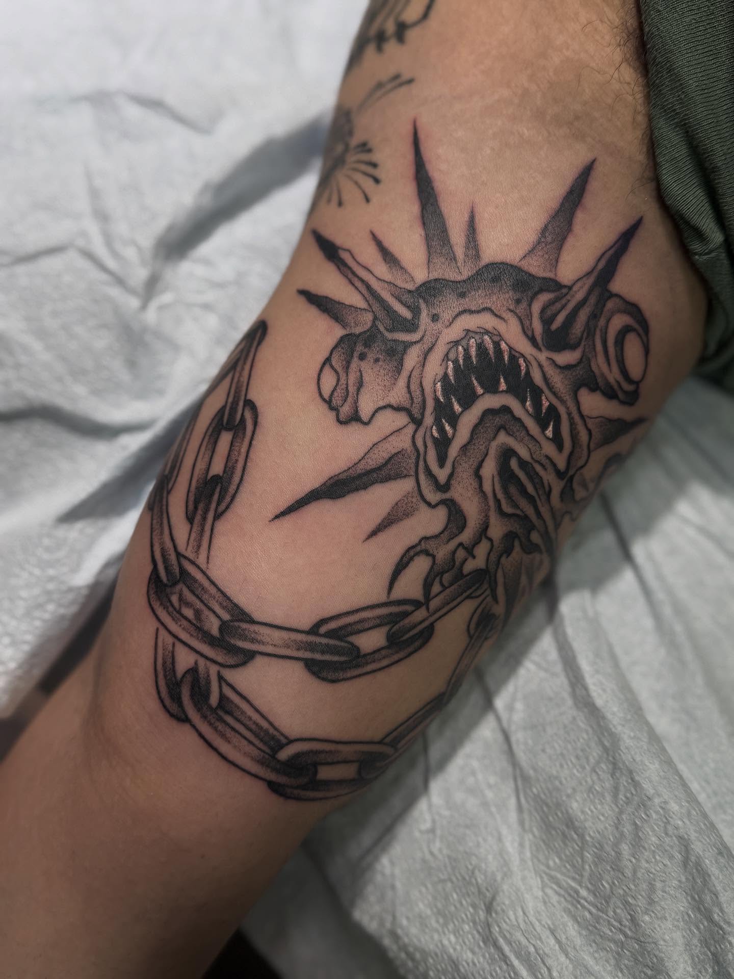 Demon head with chains dotwork tattoo on the forearm by Andrew
