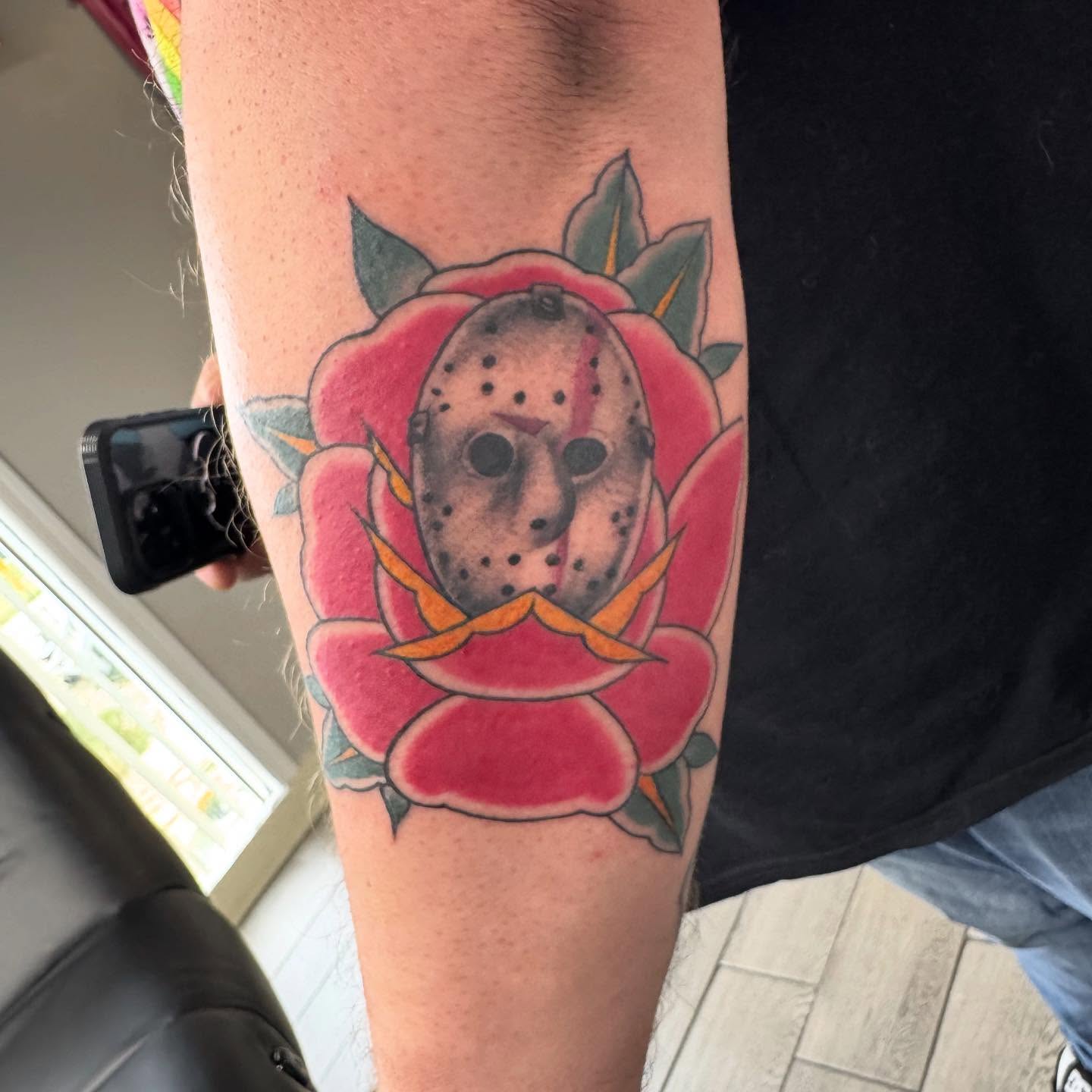 Rose with hockey mask American traditional tattoo on the forearm by Joey Flaherty