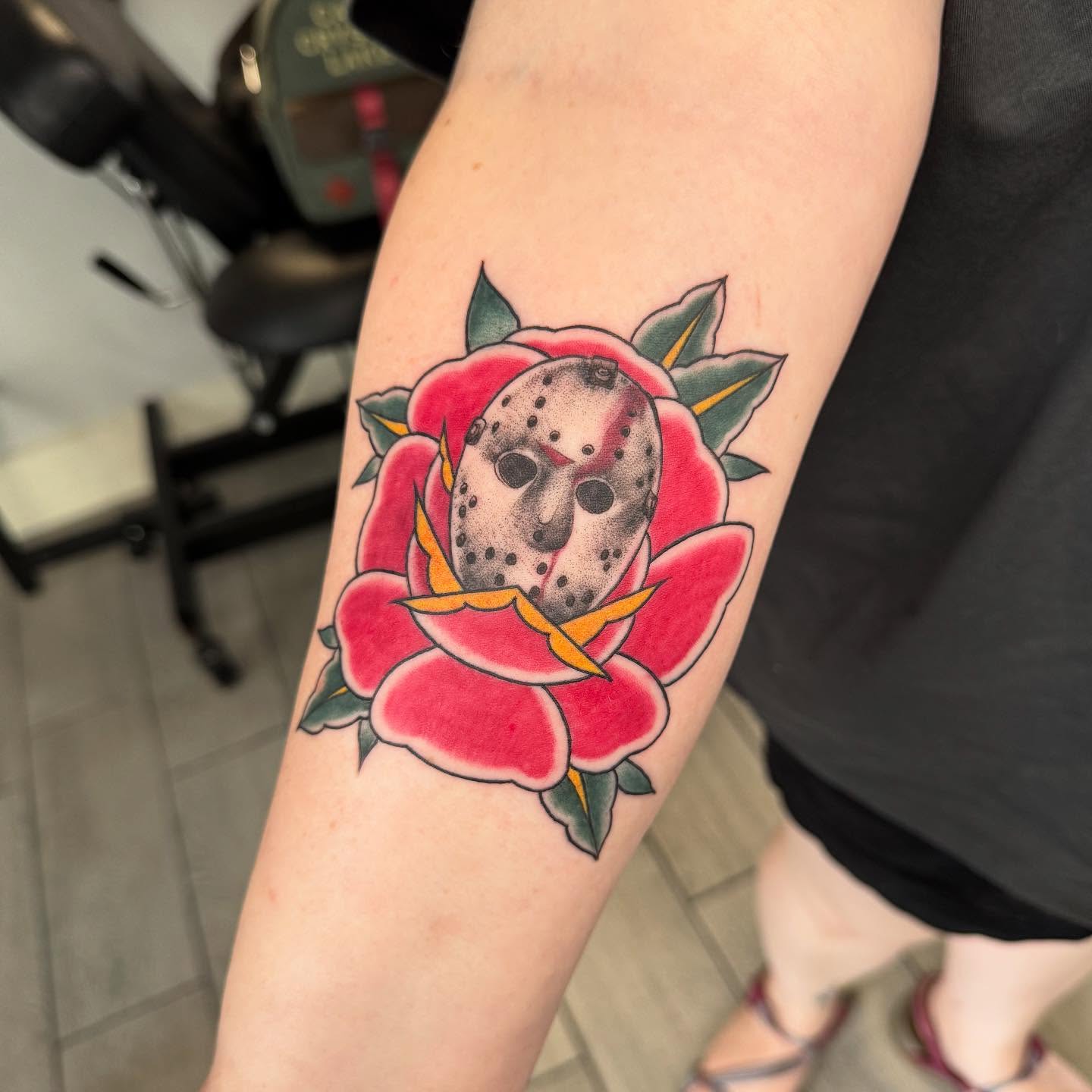 Rose with Jason Voorhees mask American traditional tattoo on the forearm by Joey Flaherty