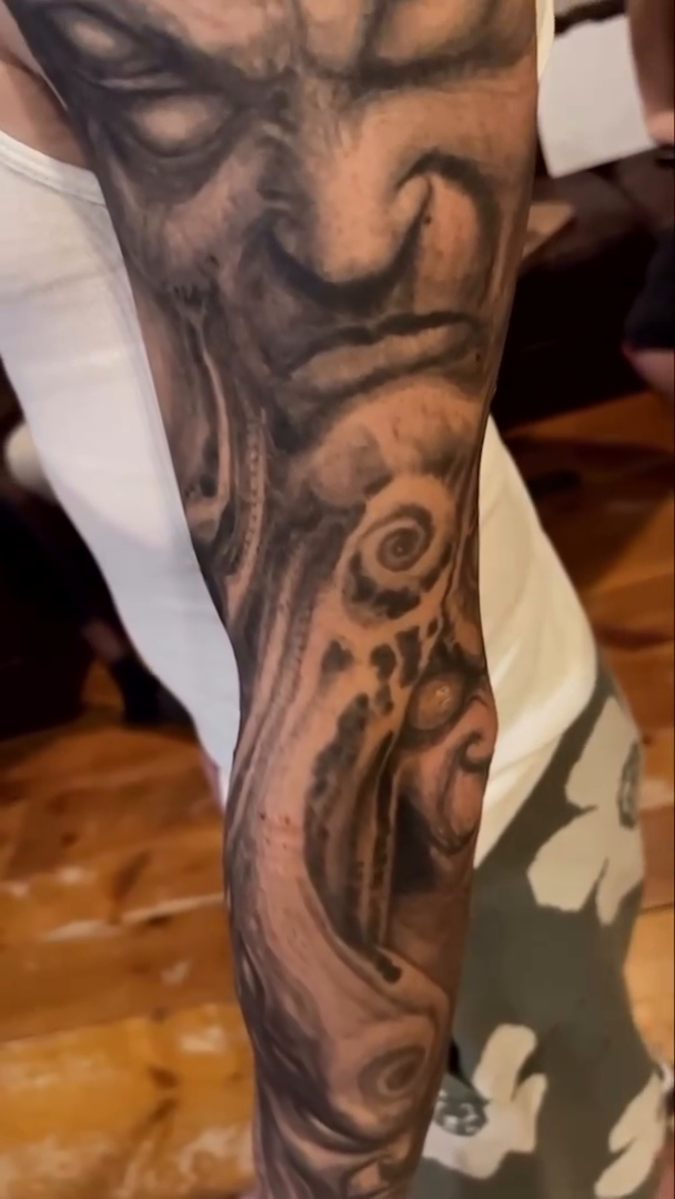 Creepy face and abstract elements dark realism tattoo by Paul Booth