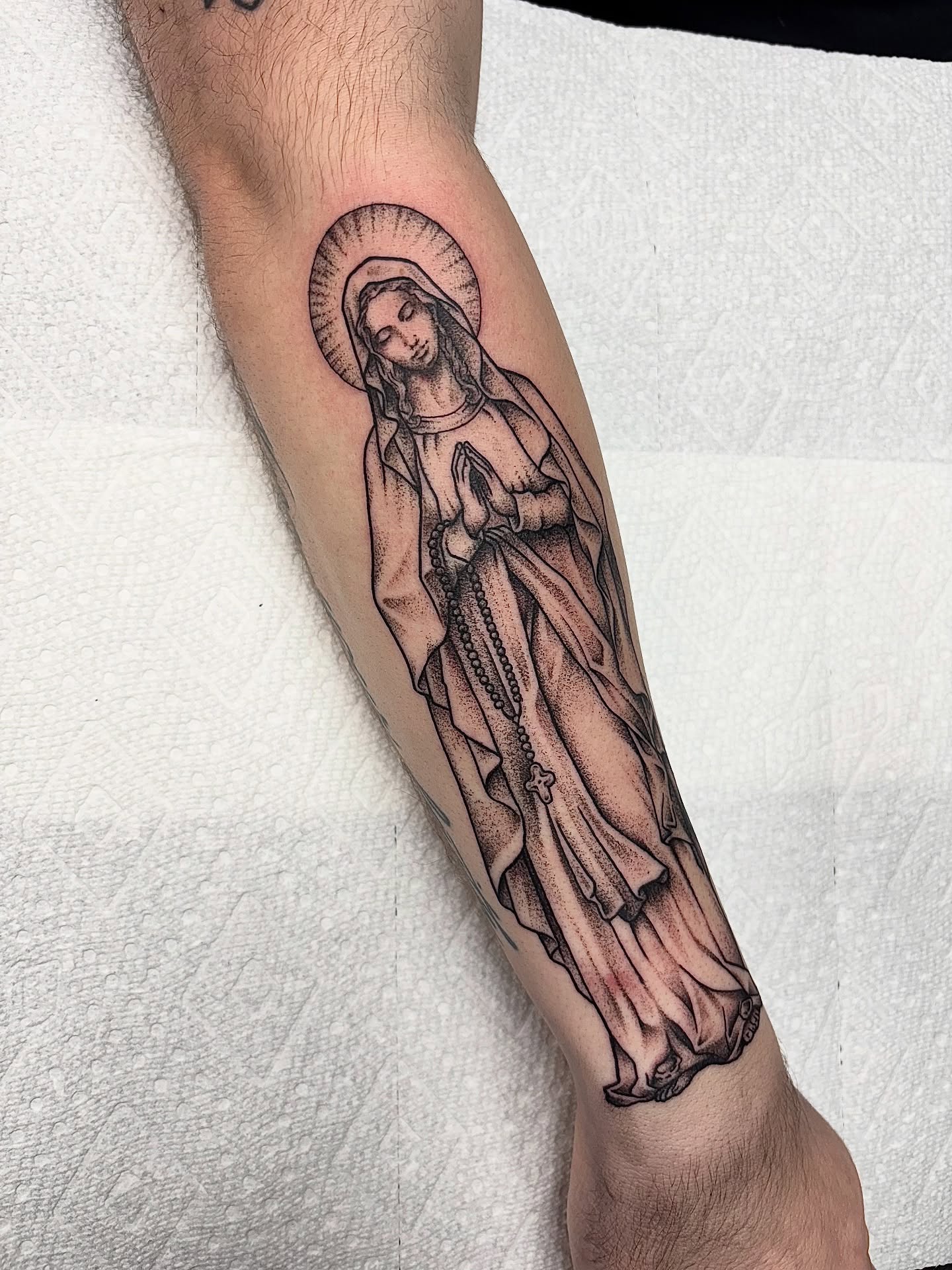 Virgin mary black and grey tattoo on the forearm by Dyllan Shipley