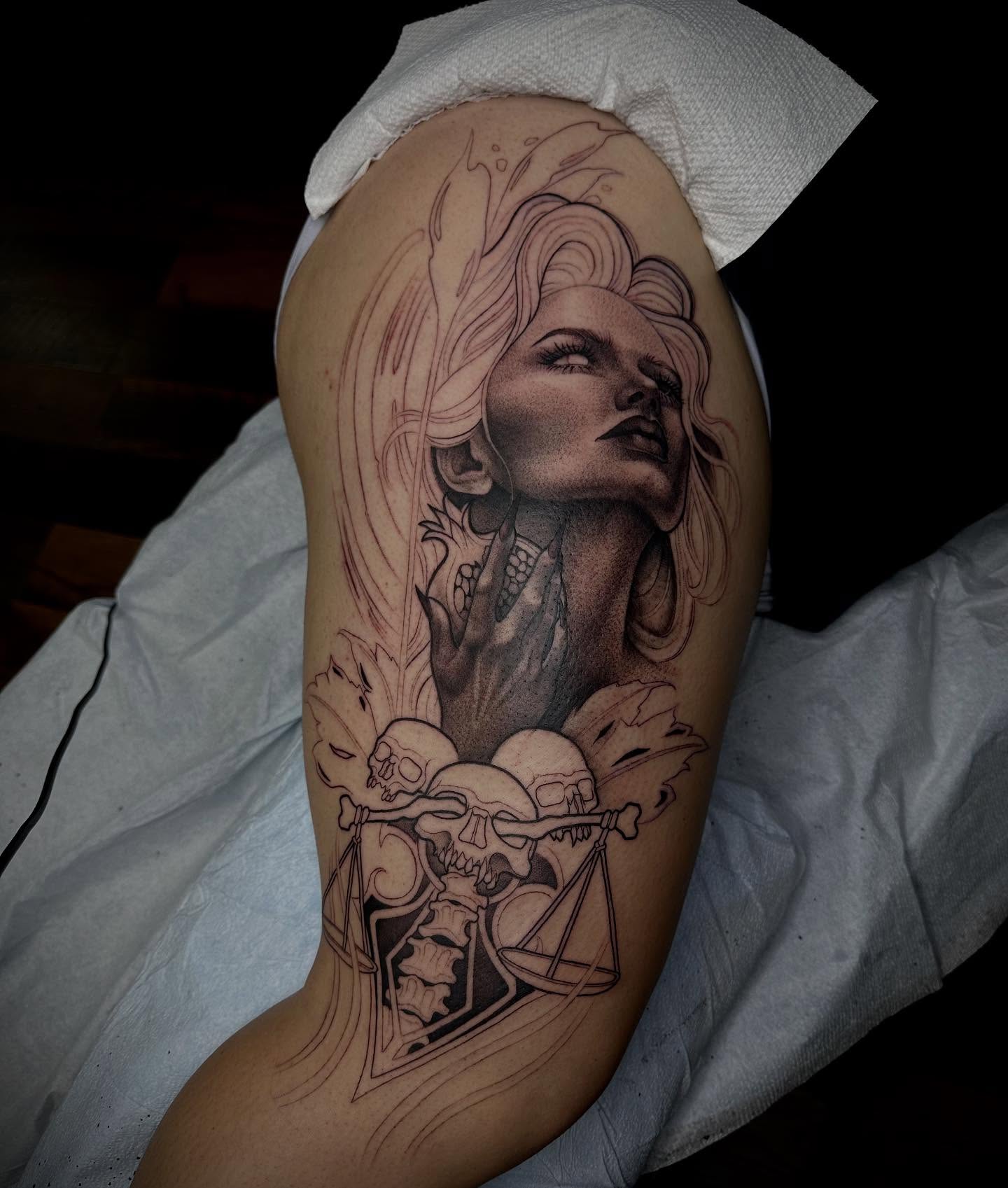 Woman with skulls realism tattoo on the upper arm by Madison Orchard Tattoos