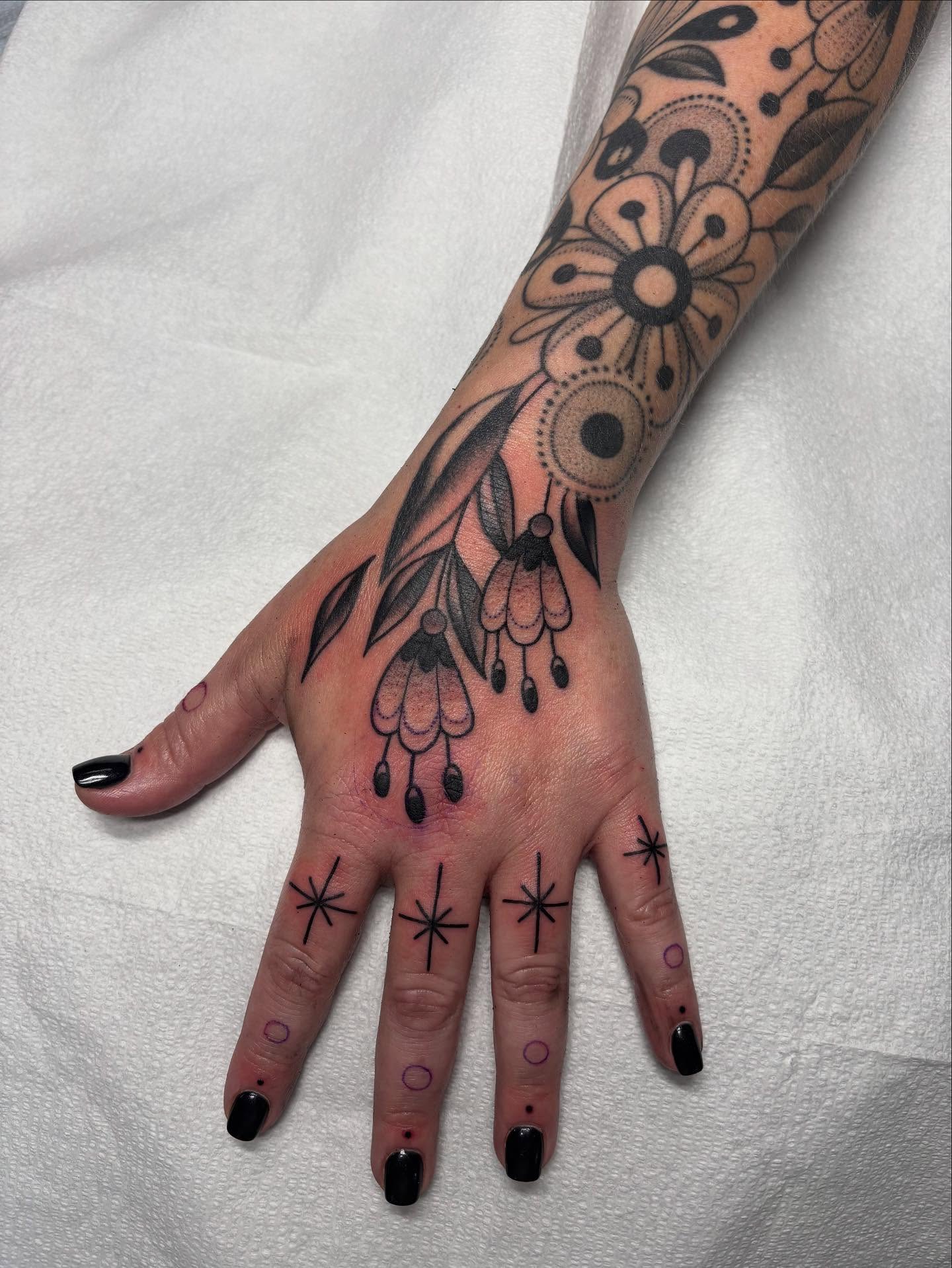 Floral and geometric design geometric tattoo on the hand by Victoria Bacon