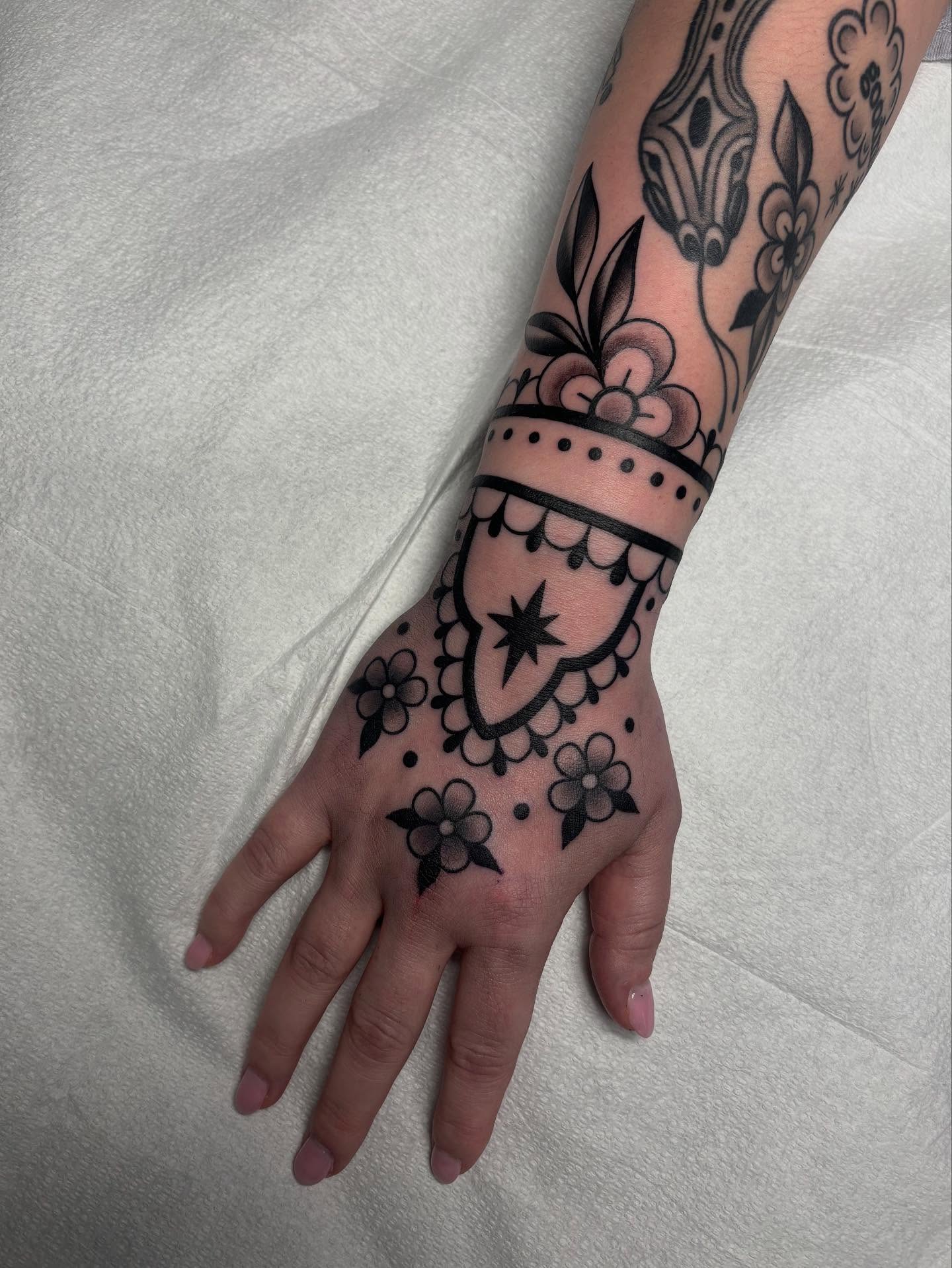 Floral and geometric design geometric tattoo on the hand by Victoria Bacon