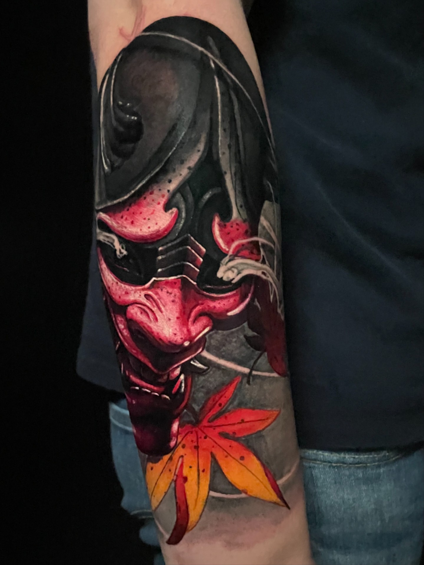Mask and maple leaf dark realism tattoo on the forearm by Sirvonesmithtattoos@gmail.com