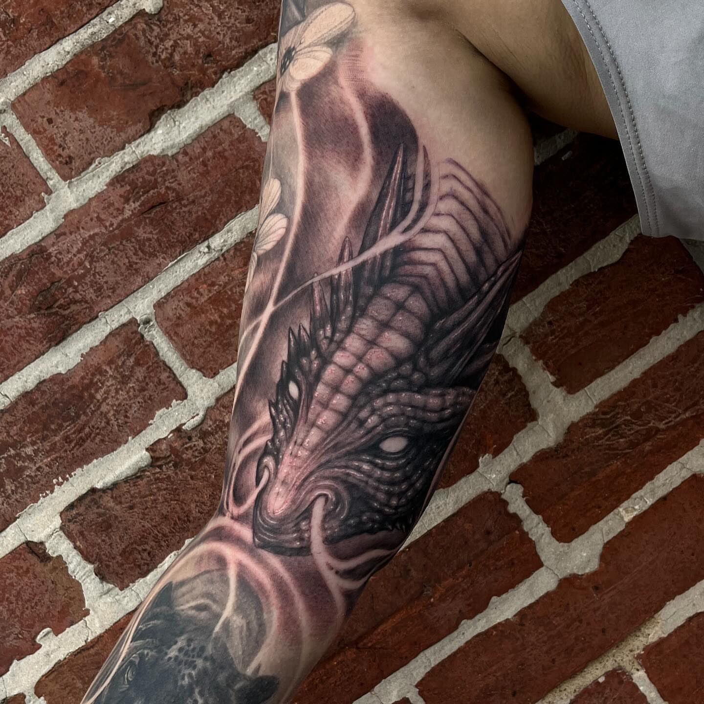 Dragon dark realism tattoo on the forearm by Adam Habecker