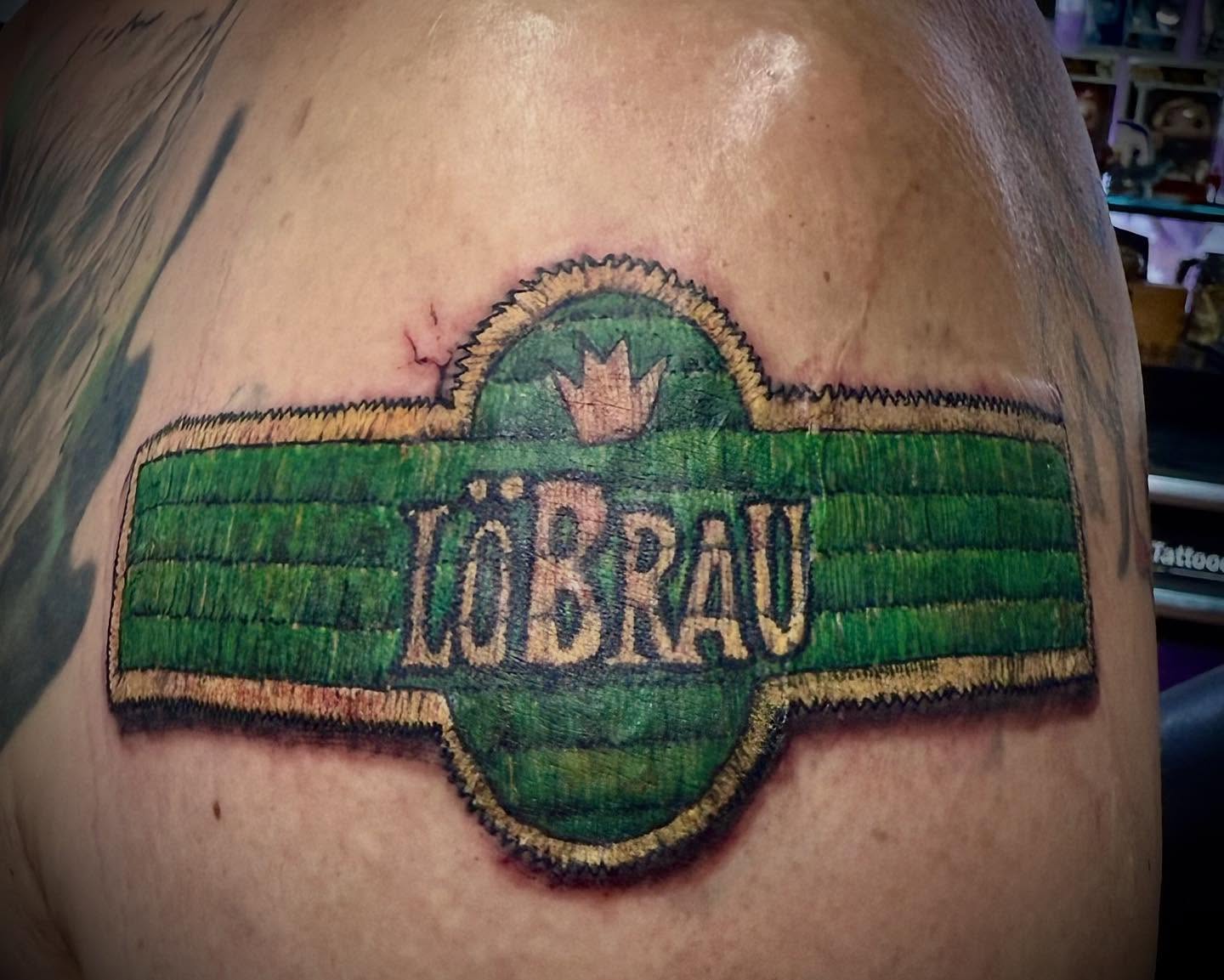 LöBRAU logo American traditional tattoo on the chest by @lady_raven_tattoo