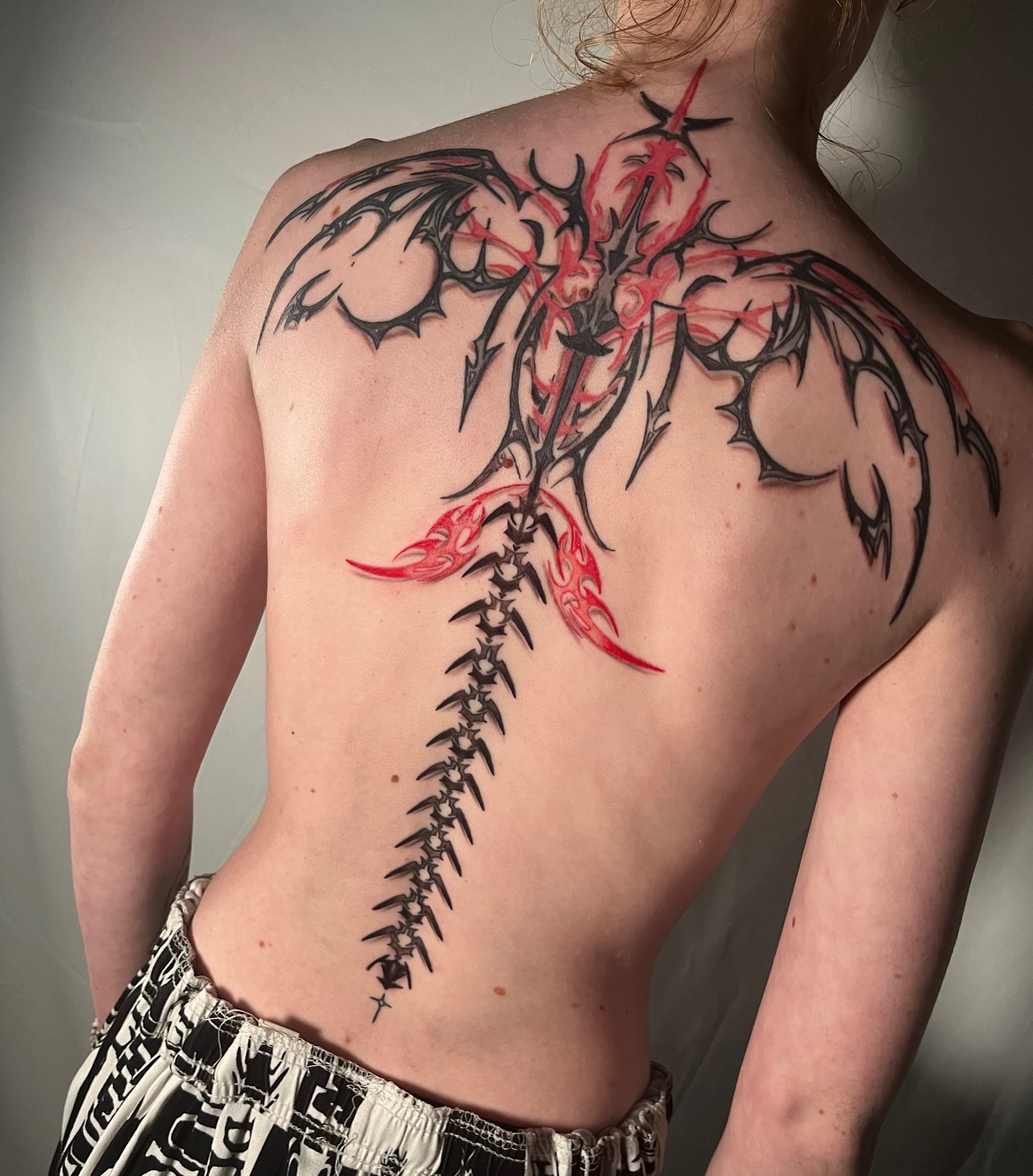 Dragon tribal tattoo on the back by Ryan Hindenach