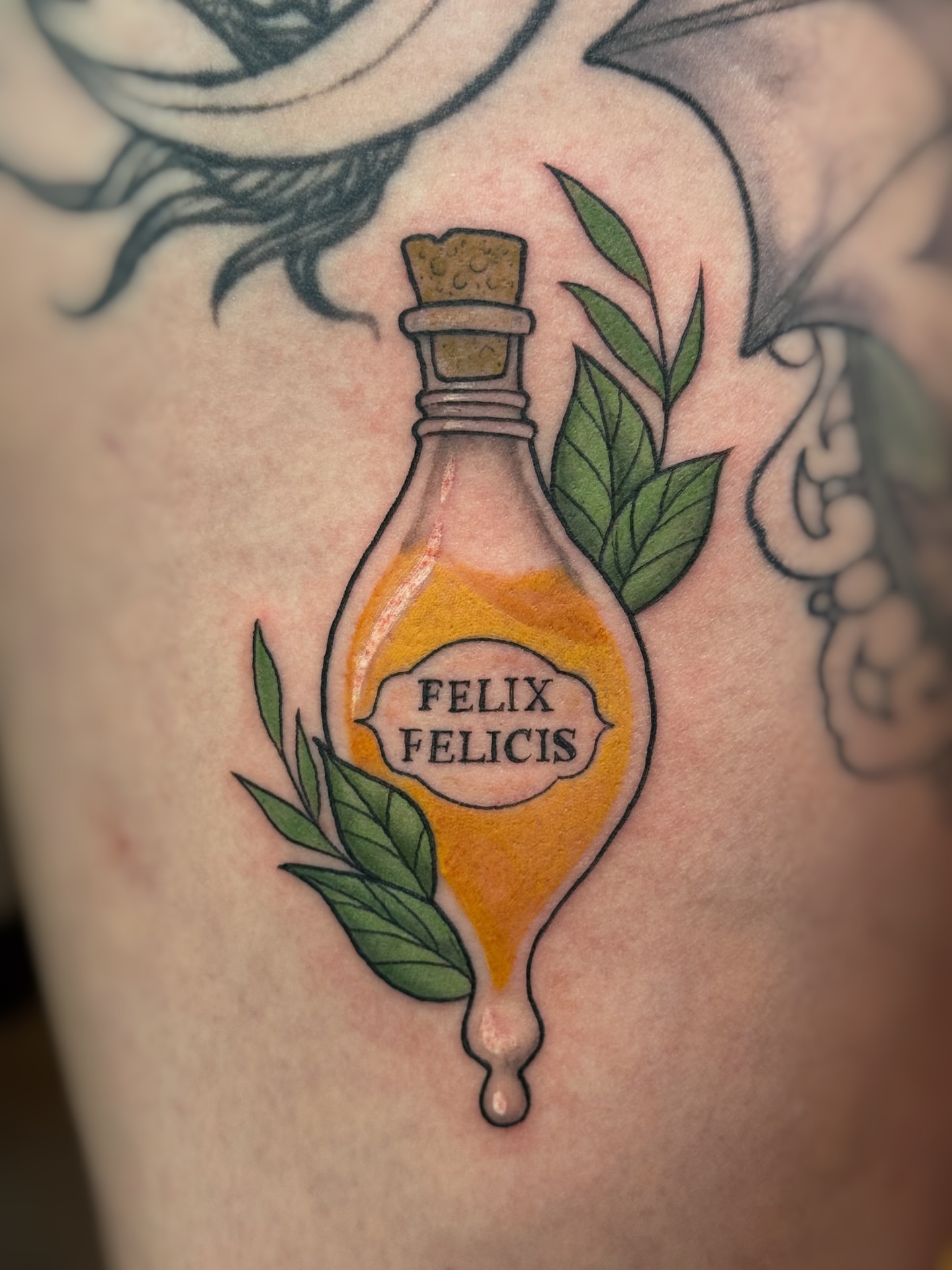 Elixir bottle realism tattoo on the thigh by Lily Bejarno