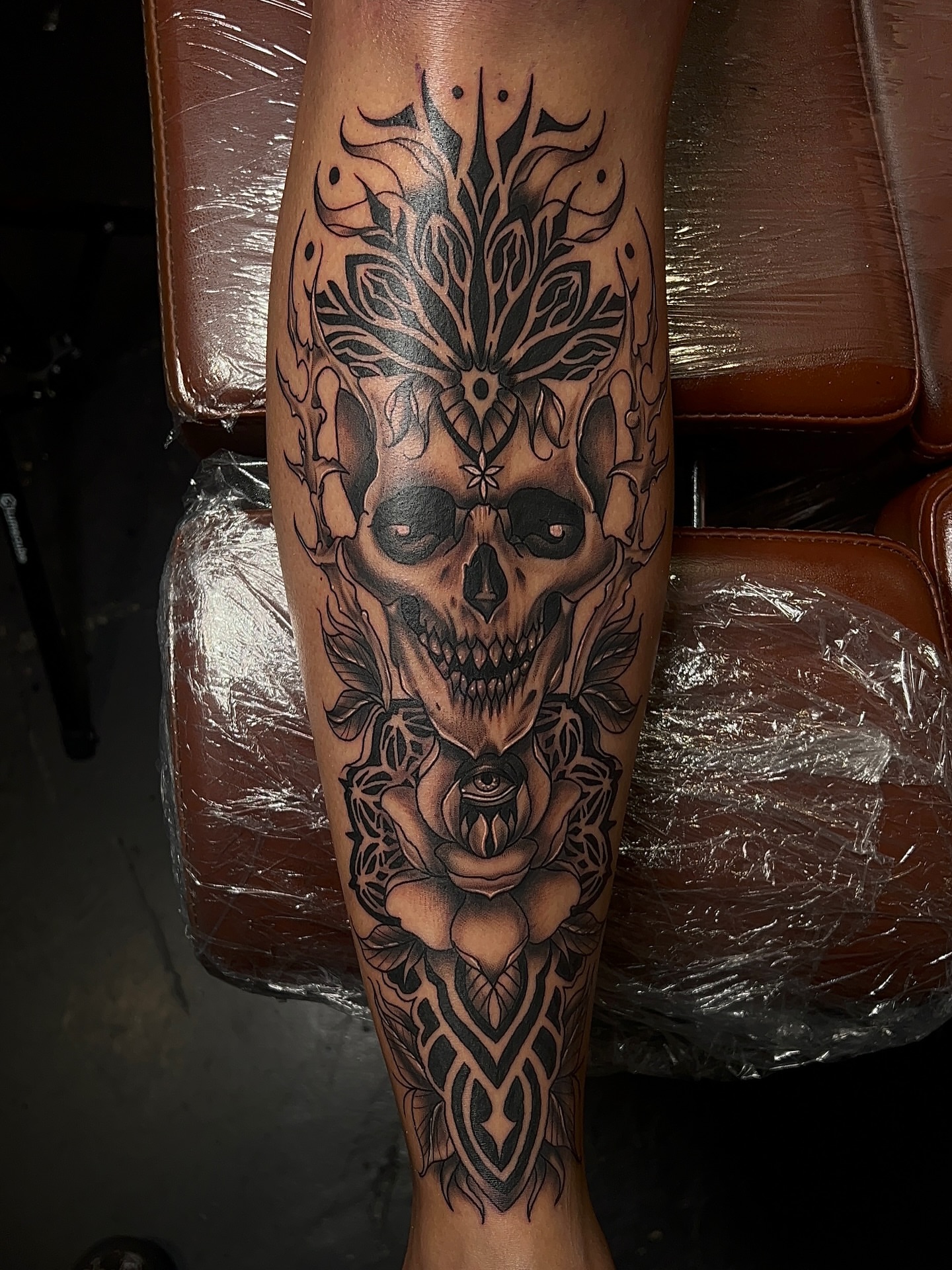 Skull with rose geometric tattoo on the calf by Denis Seregin