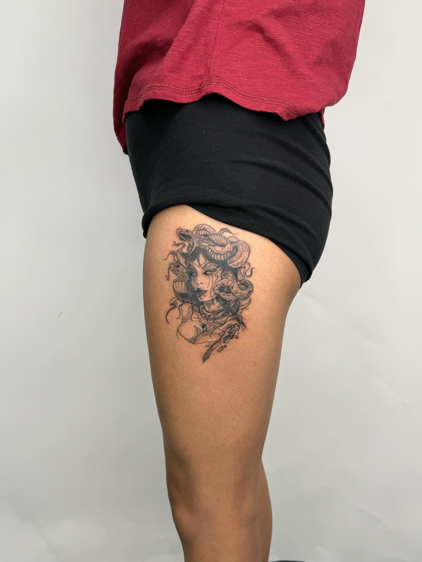 Woman with snake black and grey tattoo on the thigh by Joey tattoo