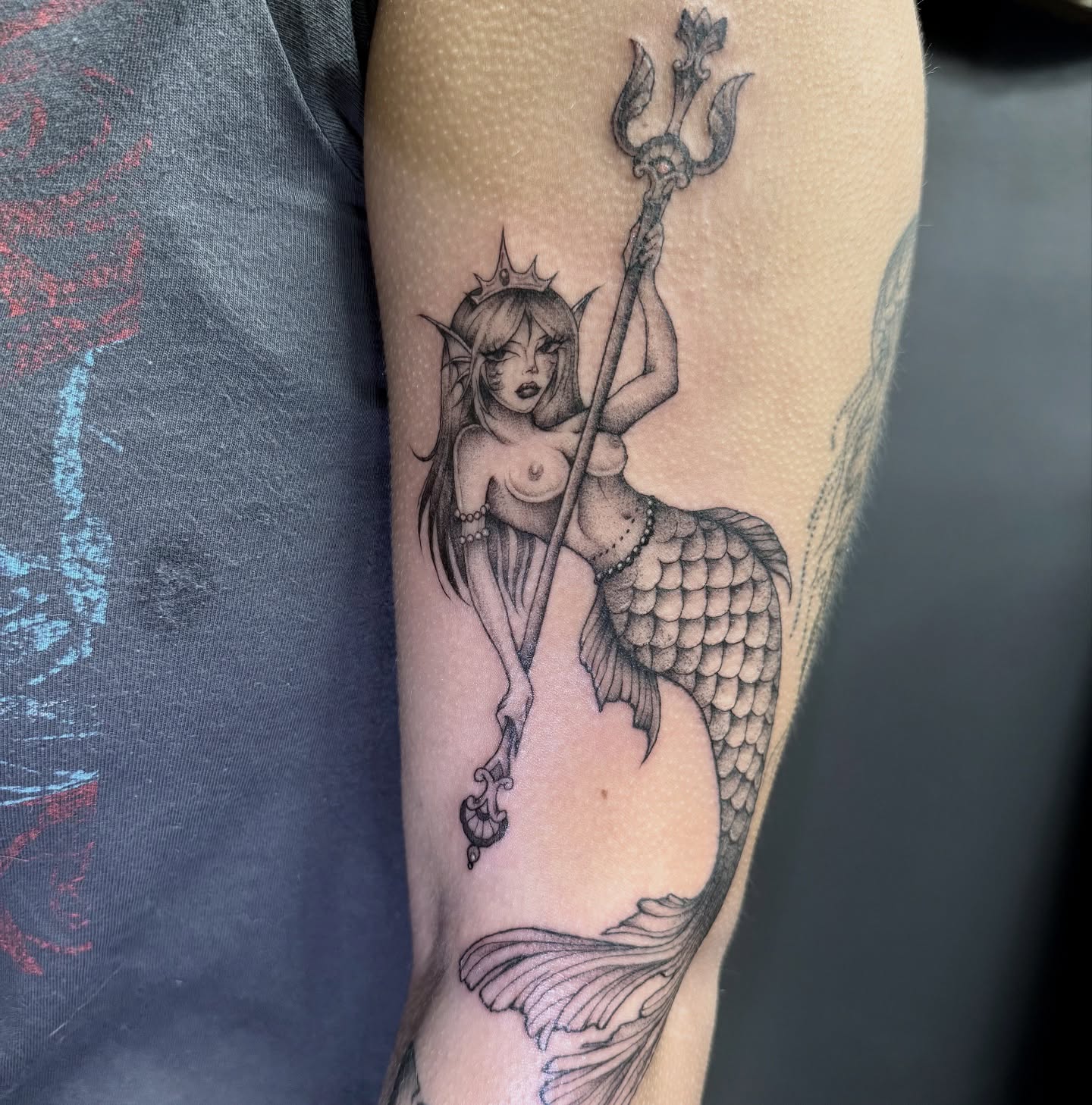 Mermaid holding trident black and grey tattoo on the forearm by dinah