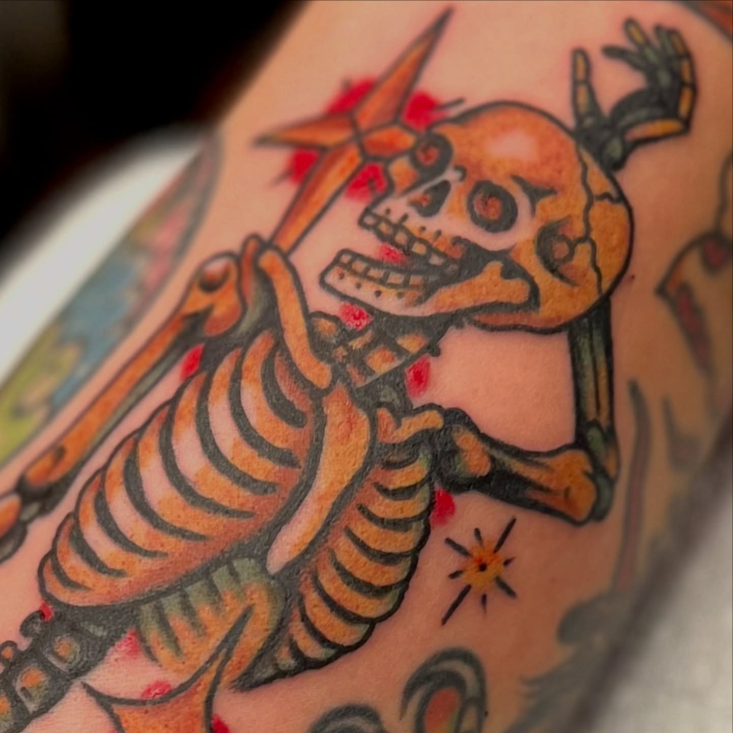 Skeleton playing guitar American traditional tattoo on the upper arm by @brandonhuckabey, Denver, Colorado