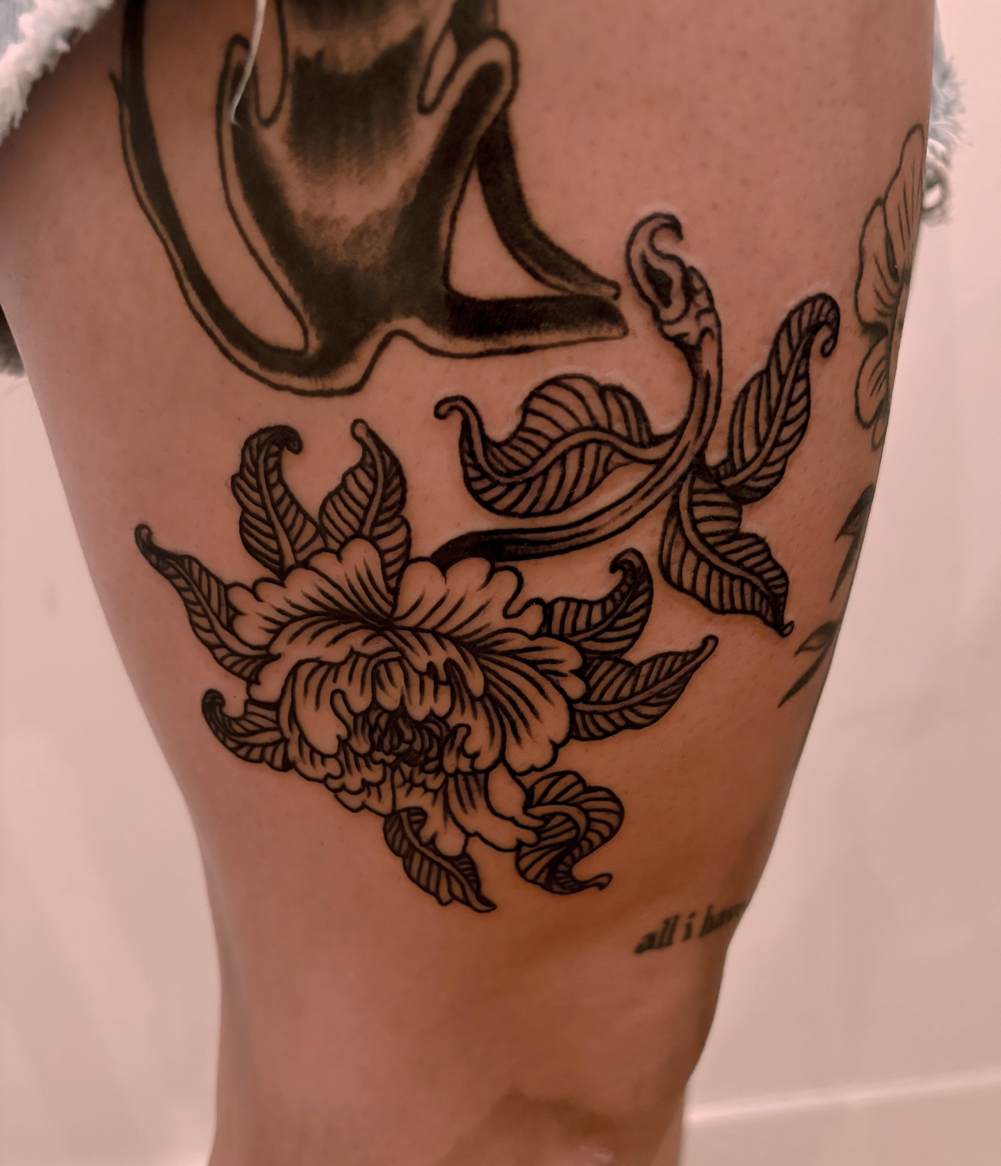 Peony and snake black and grey tattoo on the thigh by Francis Cassidy