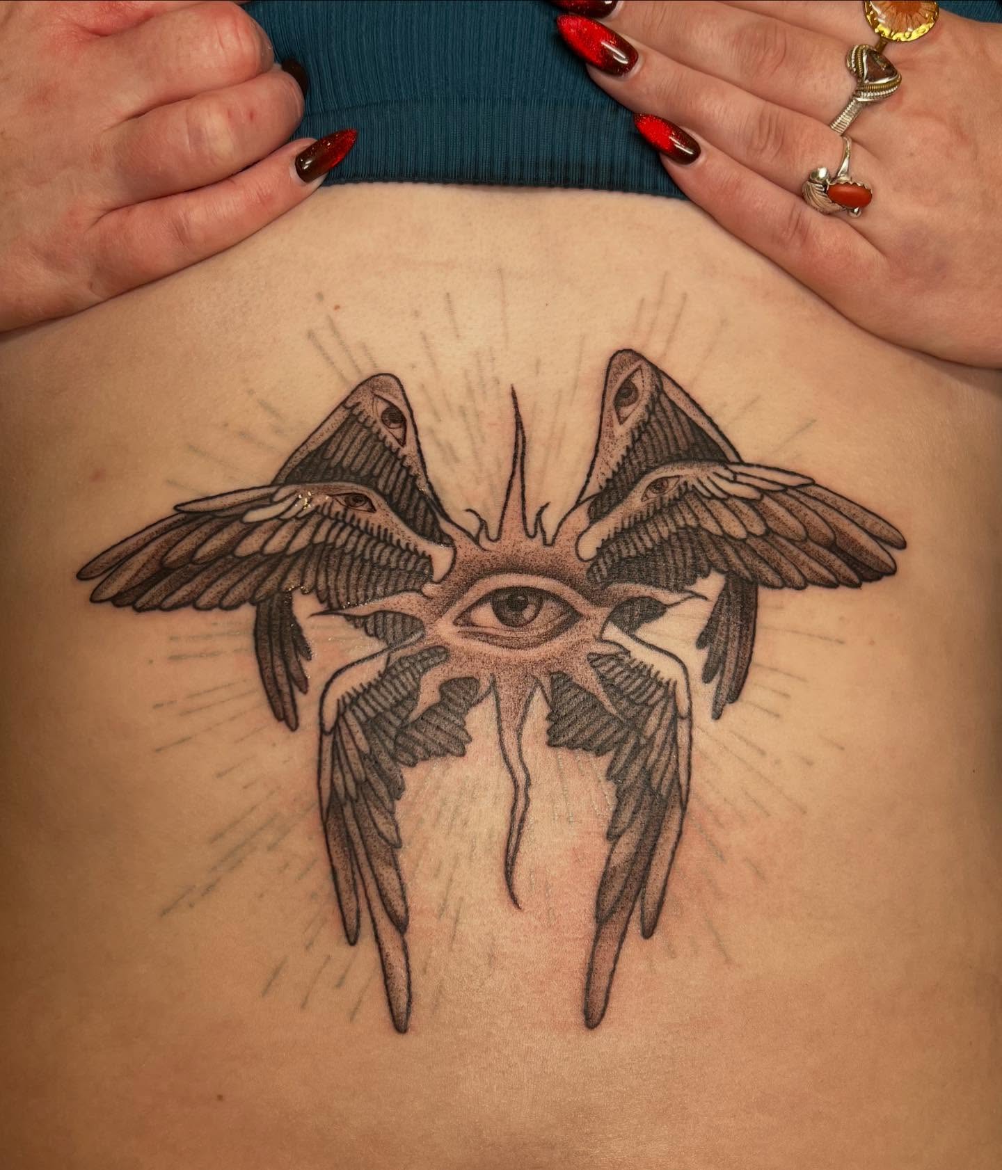 Eye with wings black and grey tattoo on the back by sarah bug