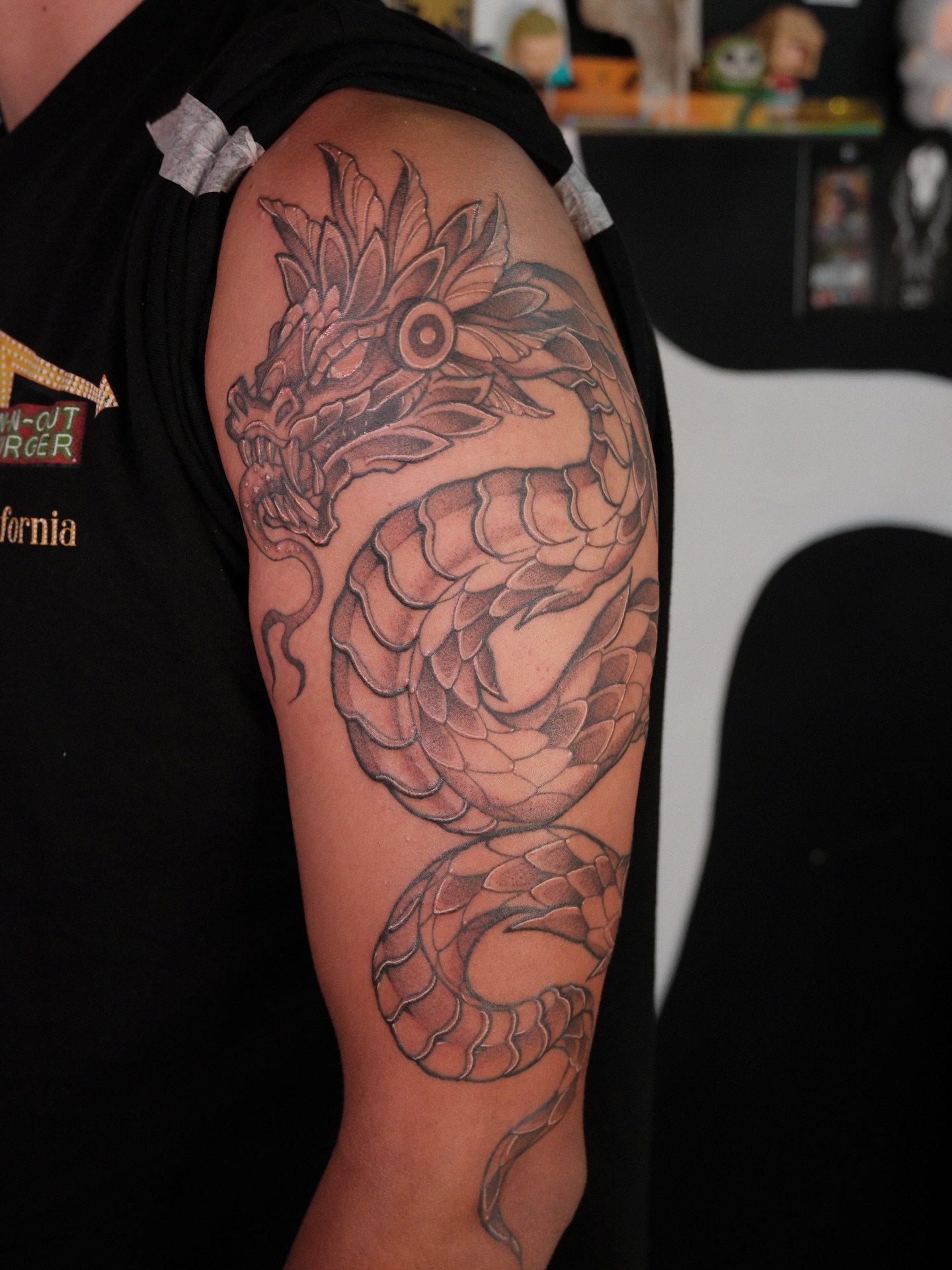 Dragon black and grey tattoo on the upper arm by Velvet, Seattle, Washington