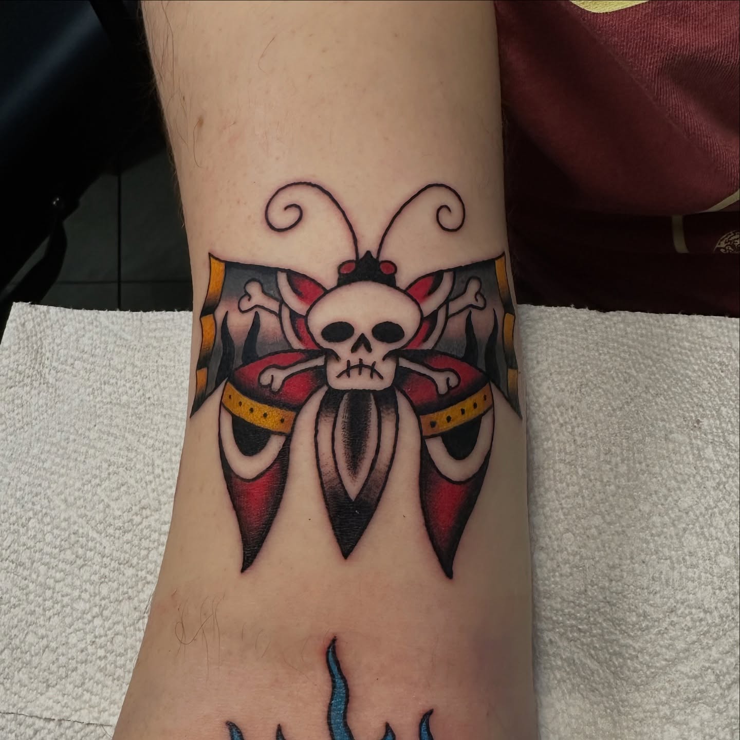 Skull and butterfly American traditional tattoo on the forearm by Emily Masa