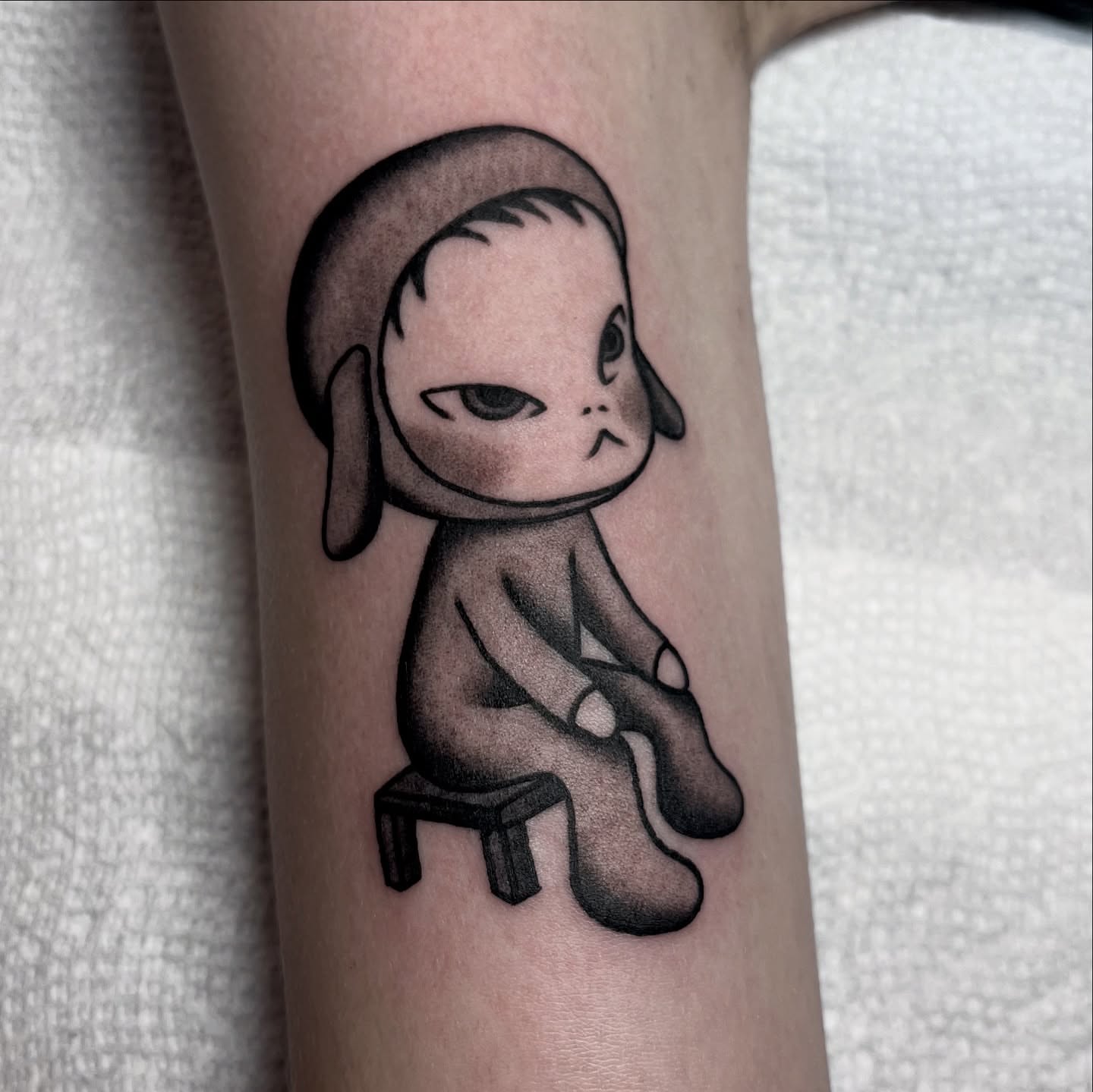 Chibi character black and grey tattoo on the forearm by Téa Fish
