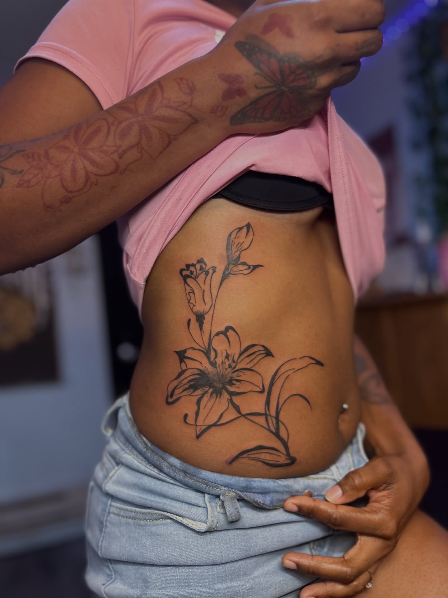 Lily and flowers black and grey tattoo on the ribs by Kiersten Tickle