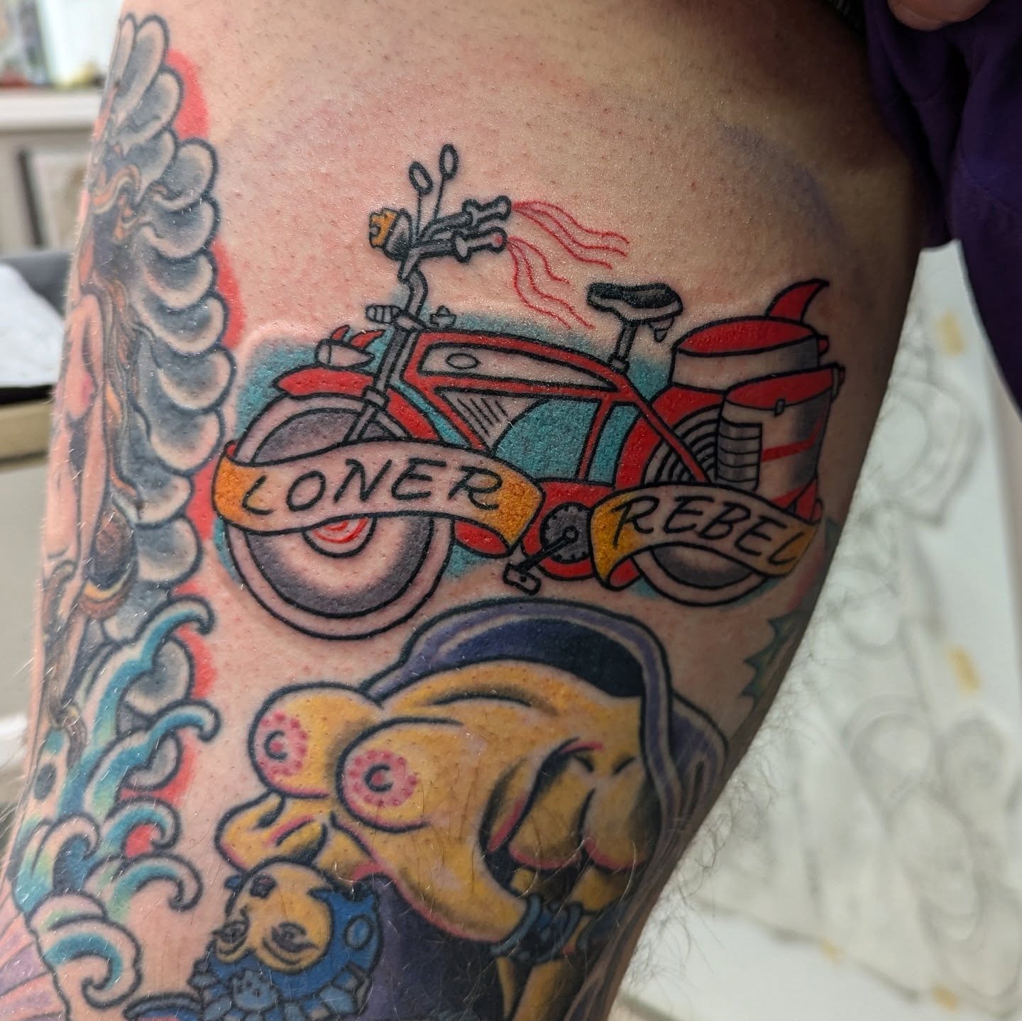 Motorcycle with banner American traditional tattoo on the thigh by Ryan Slegel