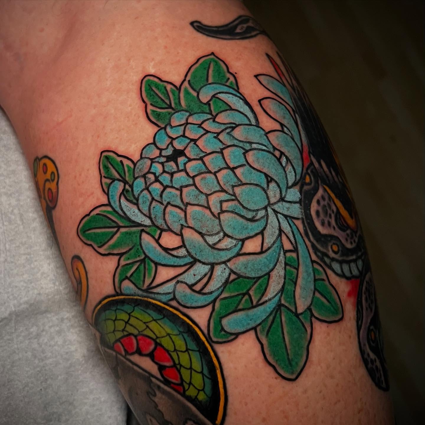 Chrysanthemum American traditional tattoo on the thigh by Chris Romolini